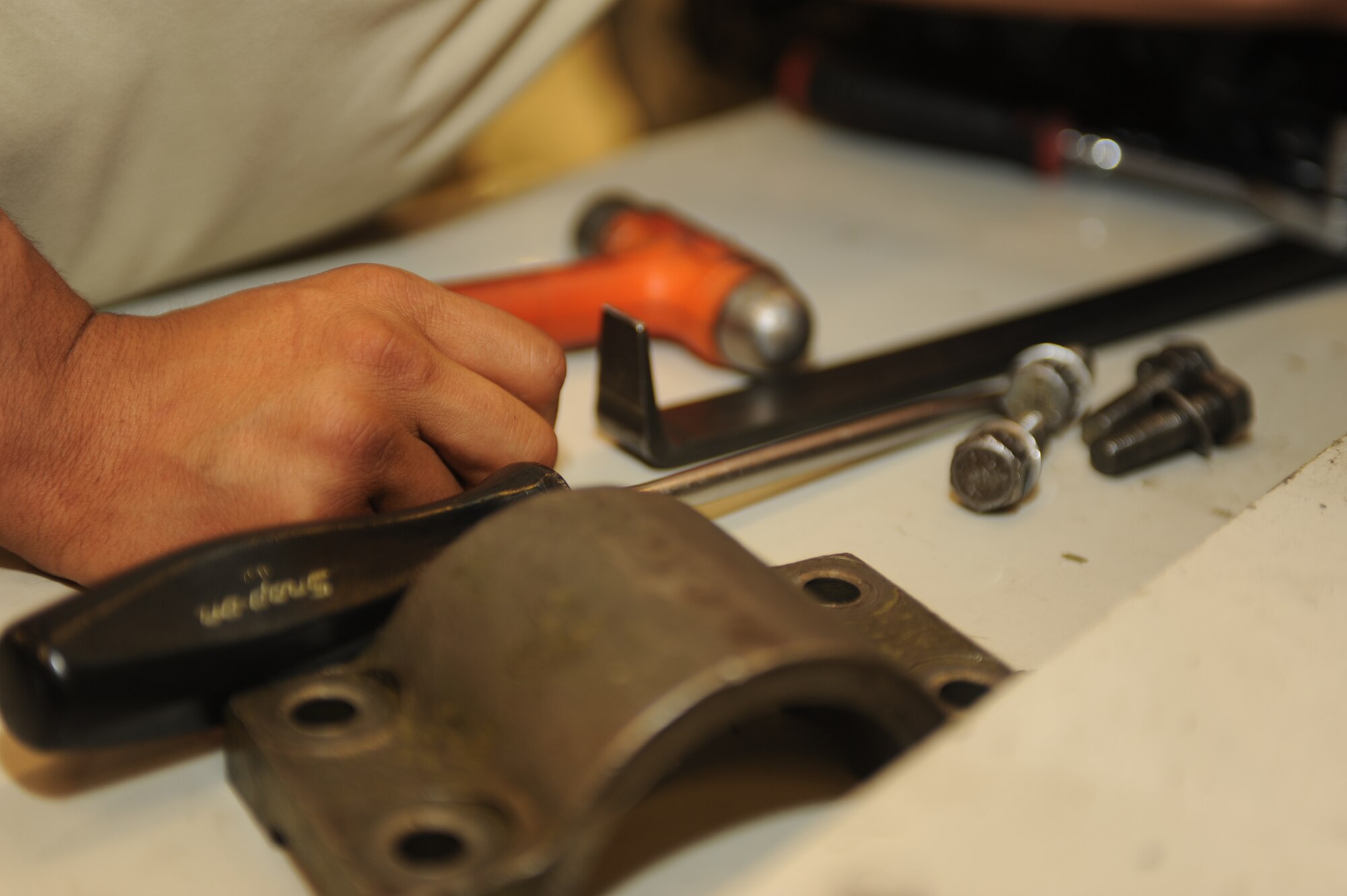U.S. Air Force Senior Airman Alex Garcia, 27th Special Operations Maintenance Squadron, handles components of a 40mm weapon recoil cylinder in a maintenance facility at Cannon Air Force Base, N.M., May 2, 2012. The purpose of the recoil cylinder is to lessen recoil or counter recoil of the weapon after firing. (U.S Air Force photo by Airman 1st Class Eboni Reece)