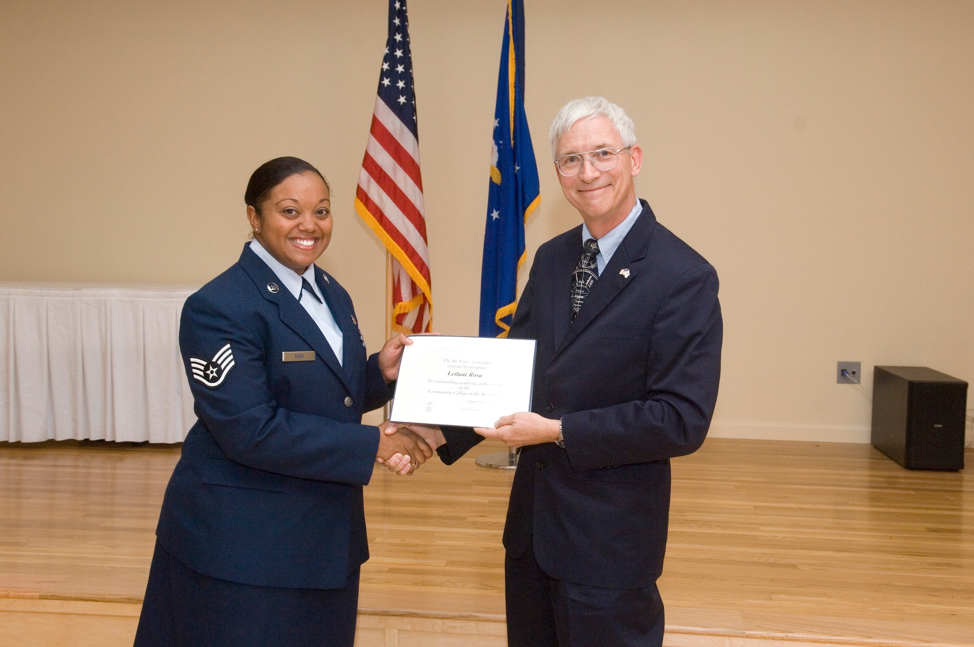 Staff Sgt. Leilani Rosa, 95th Aerospace Medicine Squadron, receives the Air Force Association Pitsenbarger Award from Randy Kelly, U.S. Air Force Test Pilot school and AFA representative. The monetary award is given out to selected Airmen who plan to earn their bachelors degree.  Rosa earned her Community College of the Air Force degree in the spring graduation ceremony May 4 at Club Muroc. (U.S. Air Force photo by Rob Densmore)