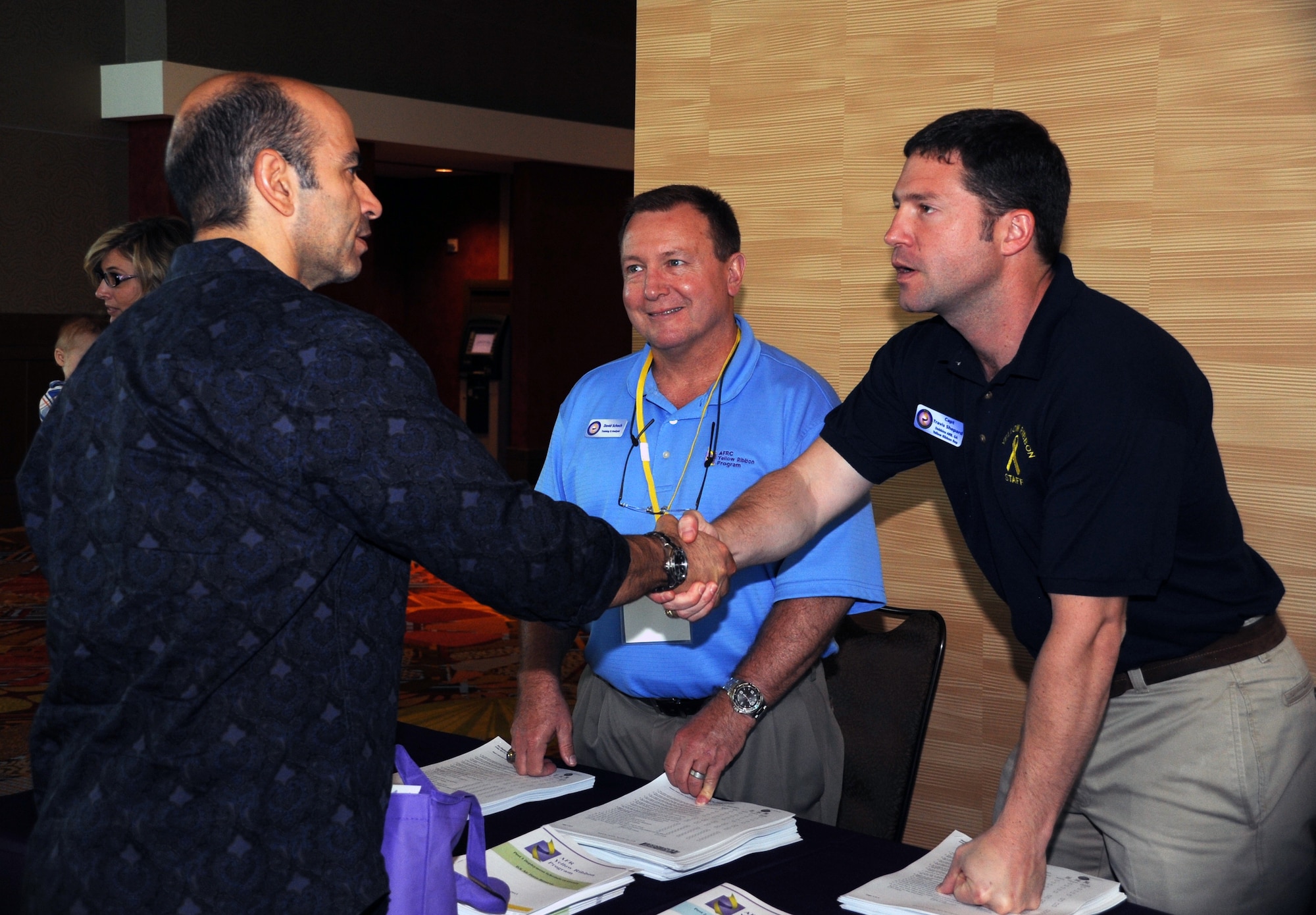 Capt. Travis Shepard, right, greets an Air Force reservist at Air Force Reserve Command's Yellow Ribbon Program in Orlando, Fla., April 28, 2012. Shepard, a Yellow Ribbon Program representative from Dobbins Air Reserve Base, Ga., helped register pre- and post-deployment Air Force and Marine Corps reservists and Individual Mobilization Augmentees for the event. (U.S.Air Force photo/Staff. Sgt. Anna-Marie Wyant)