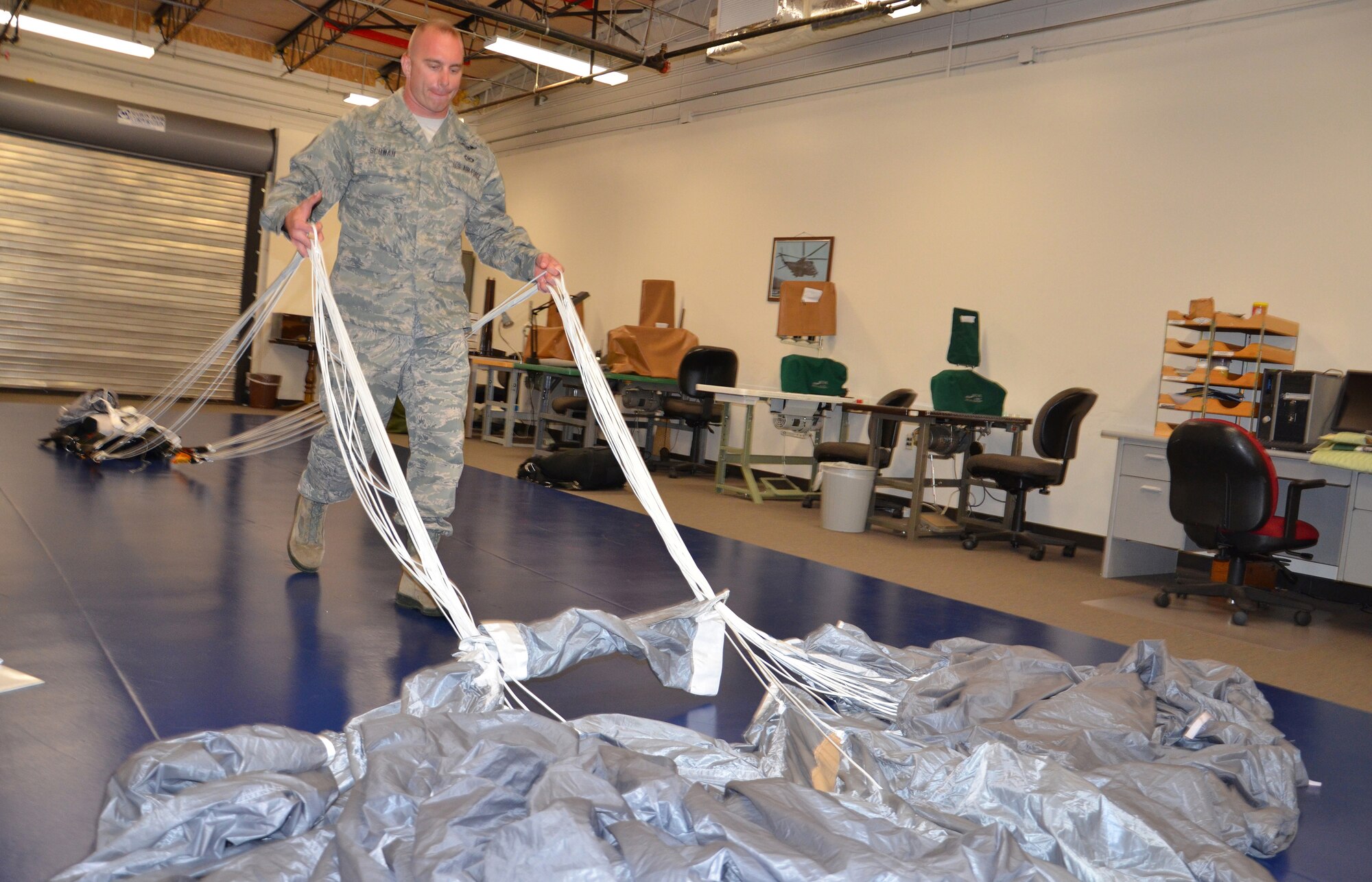 Tech Sgt. Christopher Schwan, 920th Rescue Wing, Patrick Air Force Base, Fla., Aircrew Flight Equipment Specialist reservist, makes sure cables aren't tangled as he starts to pack up a parachute used by combat search and rescue operators here. Schwan was honored as the Recruit Fire Fighter of the Year for Brevard County. He was chosen out of 70 recruits for 2012. As a fire fighter, Schwan uses the same inspiration he uses here, saving lives. "I love both of my jobs, they both give me the opportunity to save a life," said Schwan. (U.S. Air Force photo/2nd Lt. Leslie Forshaw)