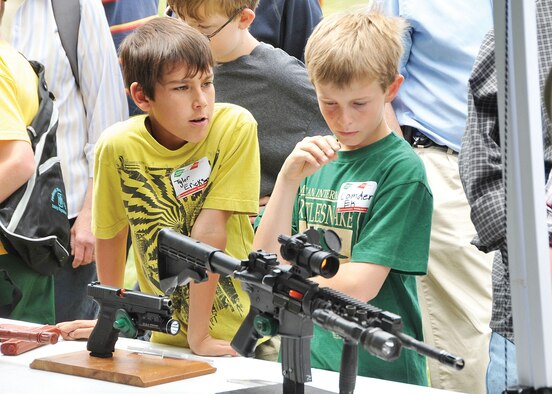 KIRTLAND AFB, N.M. -- Fifth-graders Tyler Erickson, left, from Seven Bar Elementary and Camden Ek, right, from Rio Rancho Elementary, check out weaponry from Sandia National  Labs at one of several displays. (Photo by Todd Berenger)