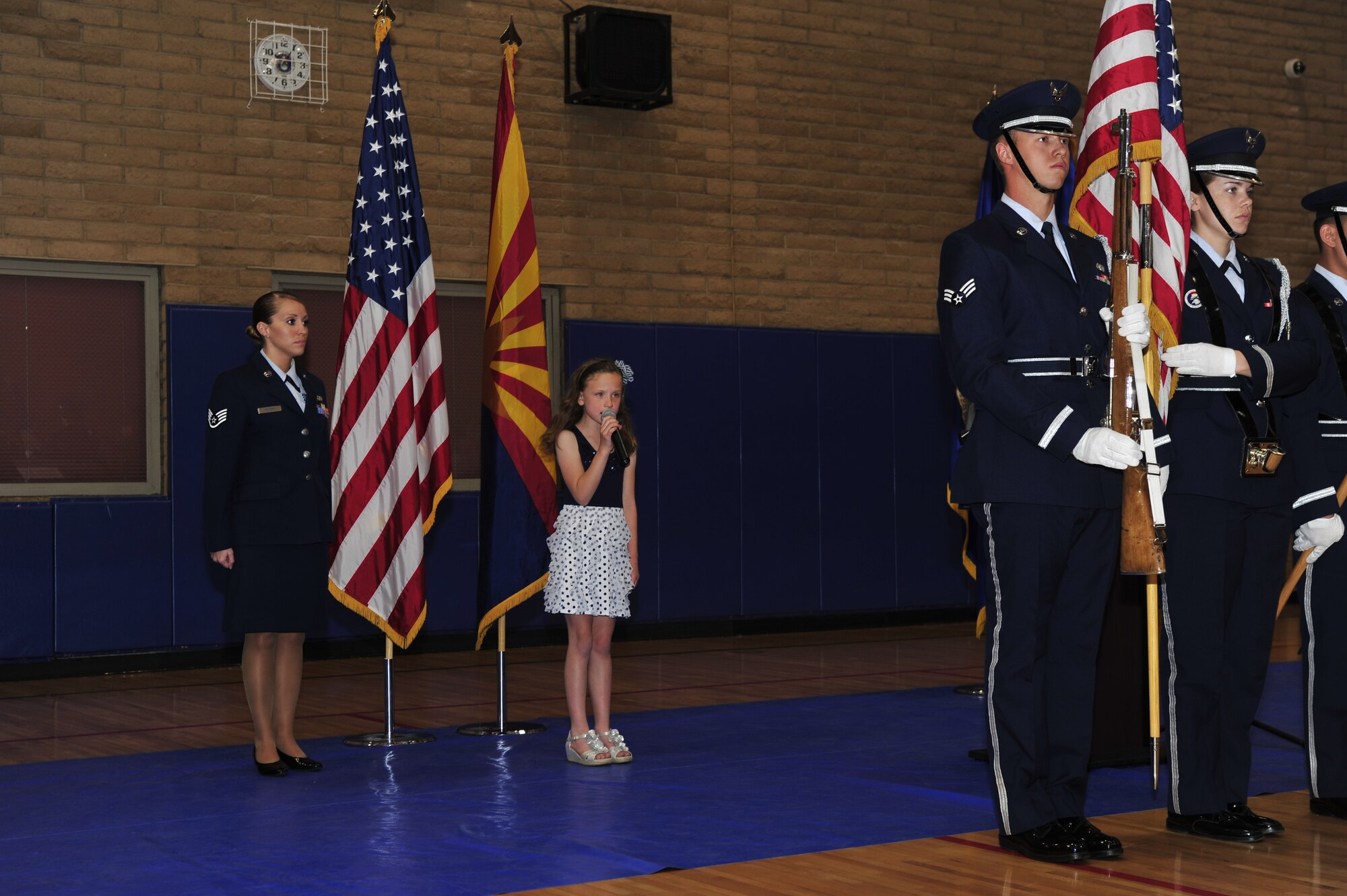 Aubrey Whitworth, 7, the niece of Lt. Col. Frank Bryant Jr., sings the national anthem during the ceremony renaming the fitness center after him Monday at Luke Air Force Base. Bryant died in the line of duty April 27, 2011, while serving as an air liaison for the Afghan air force. Bryant was adamant about fitness, engaging in sports ranging from snowboarding to wrestling.    (U.S. Air Force photo by Staff Sgt. Jason Colbert)