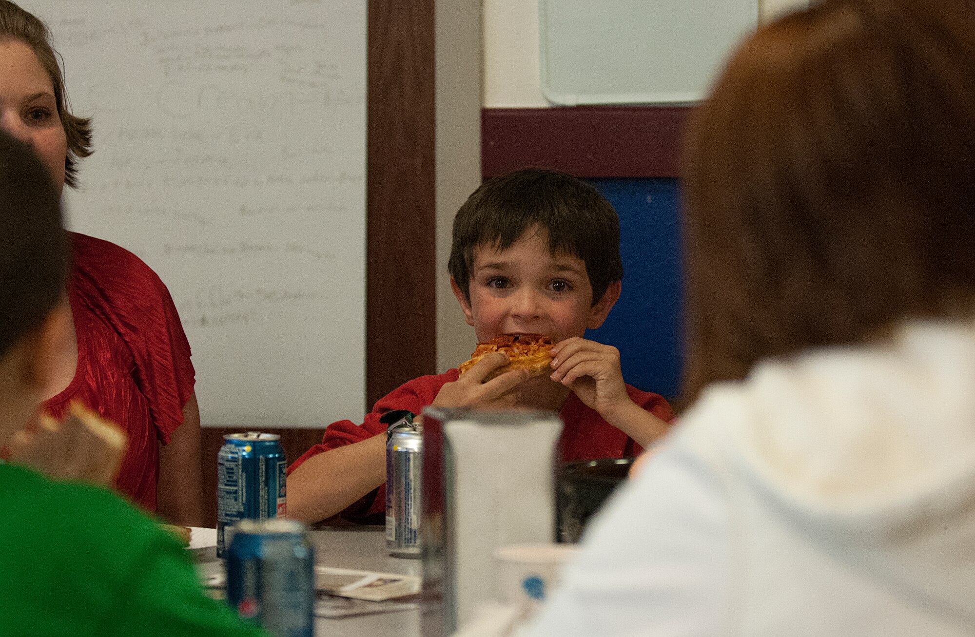 Steven Newcomer, 8, bites into a piece of pizza while at Month of the Military Child festivities at the F. E. Warren Air Force Base Youth Center April 27. Newcomer is the son of Tiffanie and Capt. Daniel Newcomer, 90th Operations Group. (U.S. Air Force photo by R.J. Oriez)