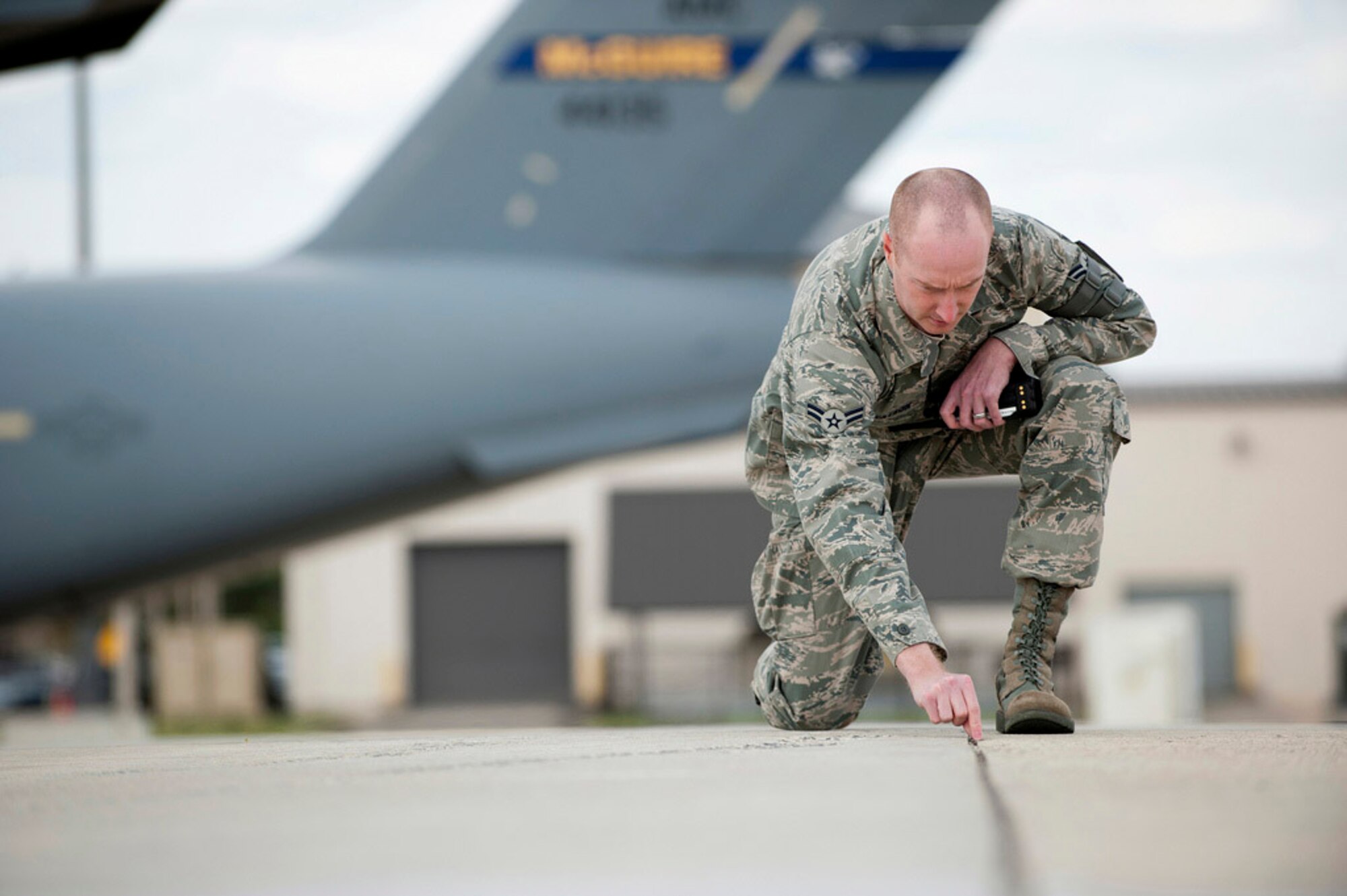 Airman 1st Class Chad Watson, 305th Operations Support Squadron airfield management specialist of Greensboro, N.C., performs a flightline inspection April 24 here. Each day six checks are performed by three shifts and one complete overall inspection of the entire airfield. Areas of concern are holes in the pavement, debris, and loose rocks that could be sucked up by the engines and cause damage to the aircraft. The fighters that will be here during the Air Show are lower to the ground and have more powerful engines which make them more susceptible to engine damage. (U.S. Air Force photo by Russ Meseroll/Released)