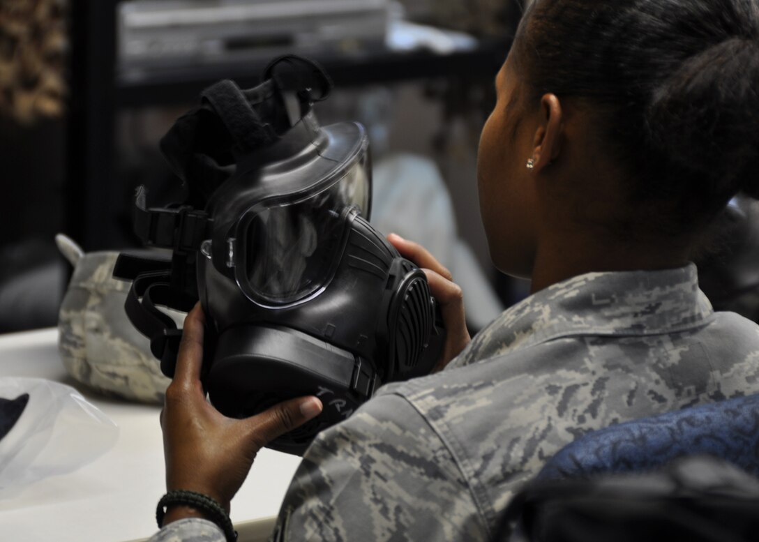 An NCO inspects her gas mask during a gas mask refresher training class at Duke Field April 13.  The course was one of more than a dozen mass training events held during the 919th Special Operations Wing's annual four-day Super Unit Training Assembly.  (U.S. Air Force photo/Dan Neely)