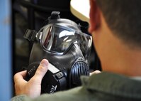 A 711th Special Operations Squadron aircrew member inspects his gas mask during a gas mask refresher training class at Duke Field April 13.  The course was one of more than a dozen mass training events held during the 919th Special Operations Wing's annual four-day Super Unit Training Assembly.  (U.S. Air Force photo/Dan Neely)