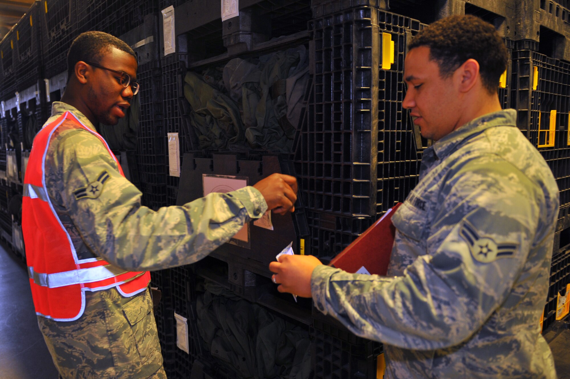 SPANGDAHLEM AIR BASE, Germany – Airman 1st Class Jamal Jeter, left, 52nd Logistics Readiness Squadron individual equipment element apprentice, places a piece of paper into an envelope for Airman 1st Class Daniel Serfass, 52nd Communications Squadron cyber transport operations apprentice, during a Phase I readiness exercise inside Bldg. 103 here May 3. The piece of paper simulates gear needed before deploying and, once the papers are gathered, accountability checks are done to ensure all necessary equipment is collected. The line ensures Airmen get required medical, financial, legal, spiritual and media support before they leave for a deployment. The exercise ensures the 52nd Fighter Wing is prepared to win today’s fight by delivering precise, reliable and ready full-spectrum capabilities. (U.S. Air Force photo by Airman 1st Class Dillon Davis/Released)