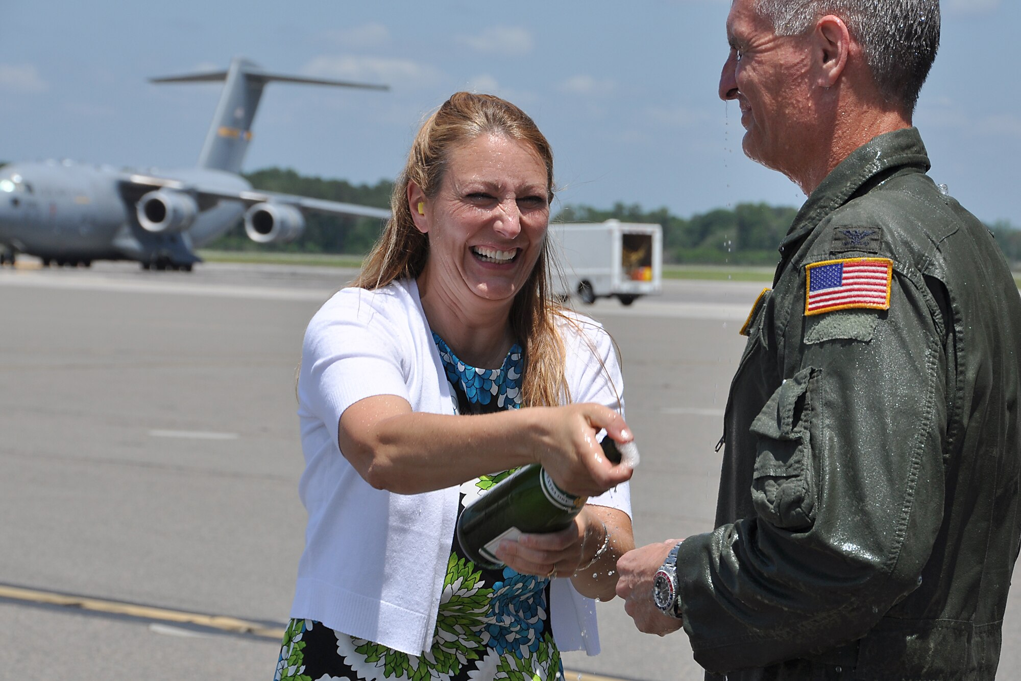 Mrs. Janet Chapman sprays champagne into the face of her husband, Col. Steven Chapman, 315th Airlift Wing commander, after he landed his "fini flight" in a Charleston C-17 Globemaster III May 3, 2012 at Joint Base Charleston, S.C. (U.S. Air Force photo by Michael Dukes)