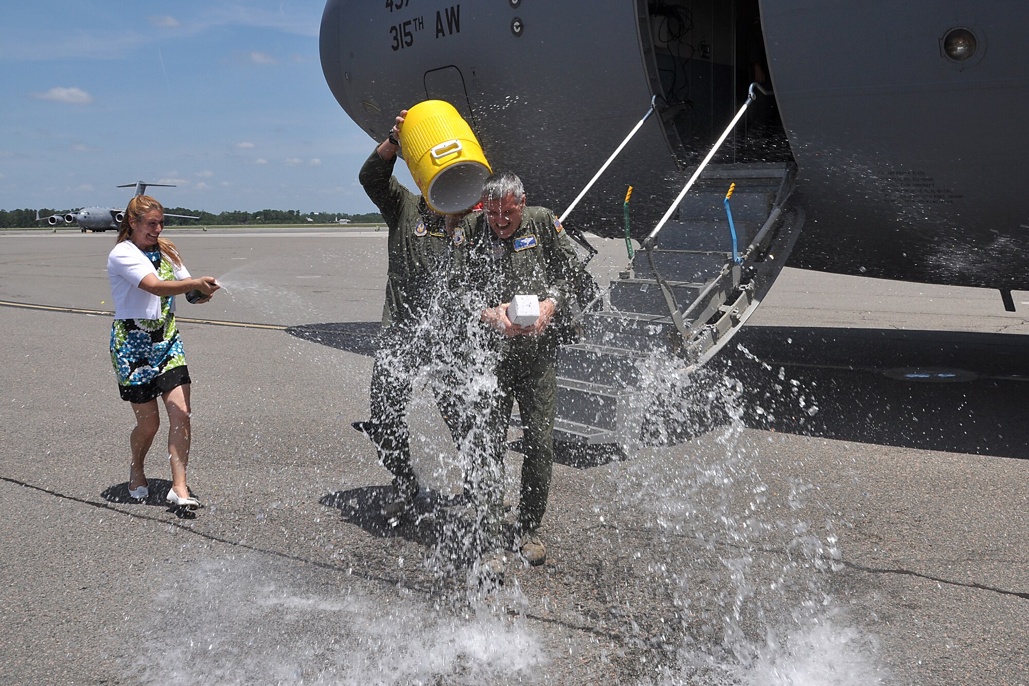 Tech. Sgt. Logan Cathcart, 317th Airlift Squadron, dumps a cooler of ice cold water over the head of Col. Steven Chapman, 315th Airlift Wing commander, after the colonel landed his "fini flight" in a Charleston C-17 Globemaster III May 3, 2012 at Joint Base Charleston, S.C. (U.S. Air Force photo by Michael Dukes)
