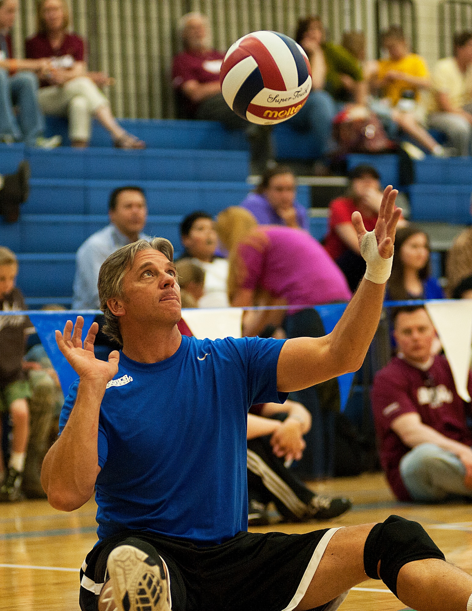 Ken Gestring, with the Air Force team, serves the ball during his team's sitting volleyball bronze medal game against the Special Operations Command team during the 2012 Warrior Games at the U.S. Air Force Academy in Colorado Springs, Colo., May 3, 2012. Air Force won 25-12 and 25-20. (U.S. Air Force photo/Val Gempis)