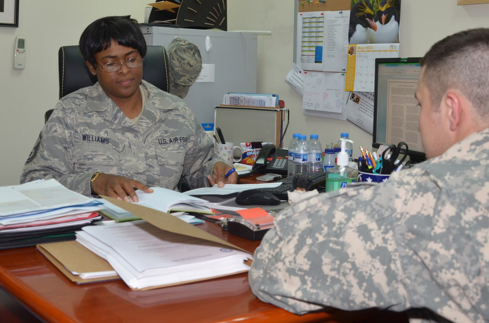 Master Sgt. Tanya Williams helps Capt. Paul Curlee prepare legal contracts May 4, 2012. Williams, the 380th Air Expeditionary Wing paralegal, helped a new Airman upon his arrival to the wing. She's deployed from Naval Air Station Joint Reserve Base Forth Worth, Texas. (U.S. Air Force photo/Senior Airman Jared Elliott)