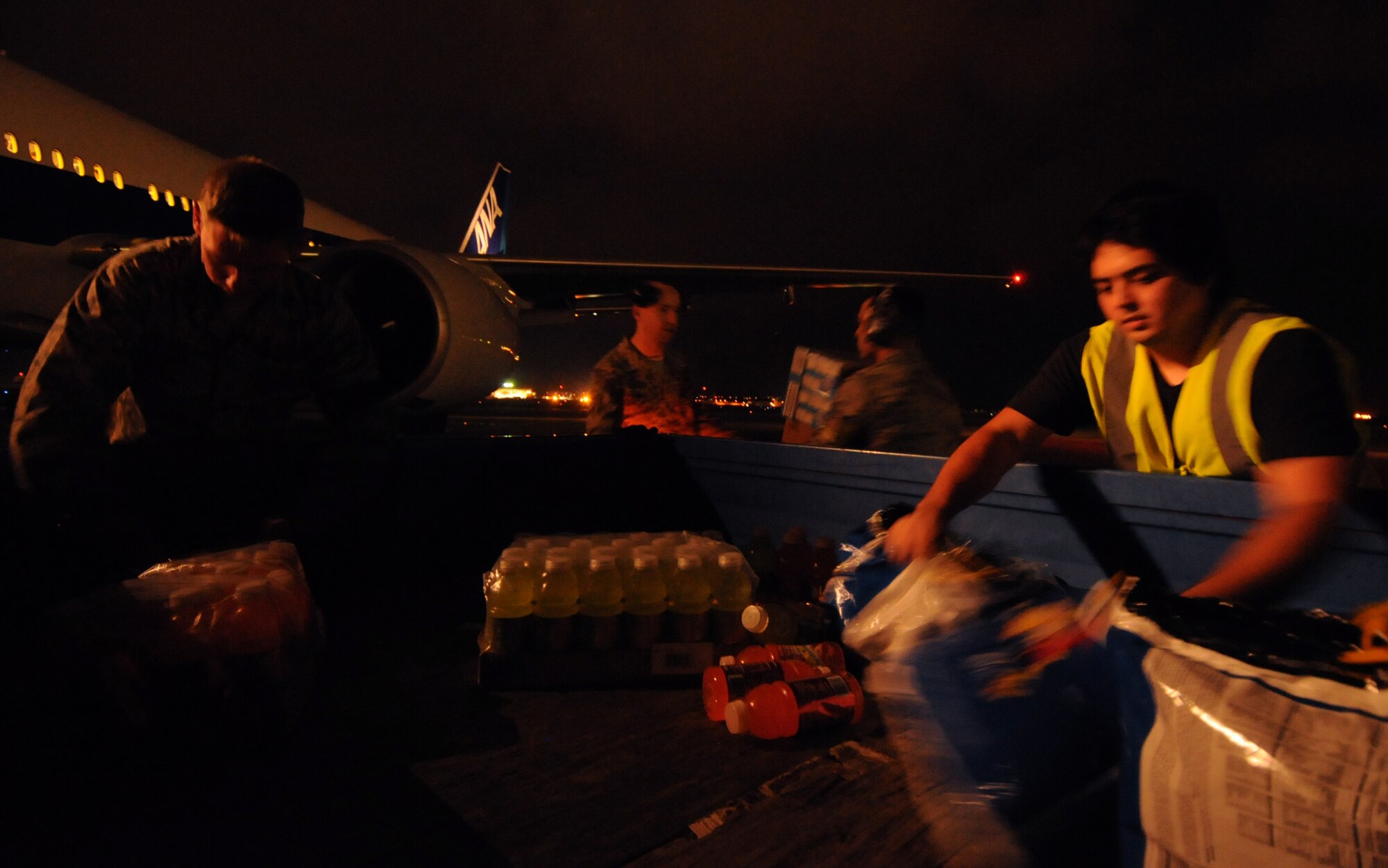 Airmen from the 733rd Air Mobility Squadron and local contractors help unload snacks and drinks to hand out to about 410 passengers aboard a commercial airliner diverted from Naha airport to Kadena Air Base May 2. Kadena welcomed two aircraft originally bound for Naha in the past two days. In both instances 18th Wing and 733rd AMS personnel assisted in providing air traffic control, ground support, snacks and drinks to crew and passengers as they waited to depart for Naha. (U.S. Air Force photo/Tech. Sgt. Jason Lake)
