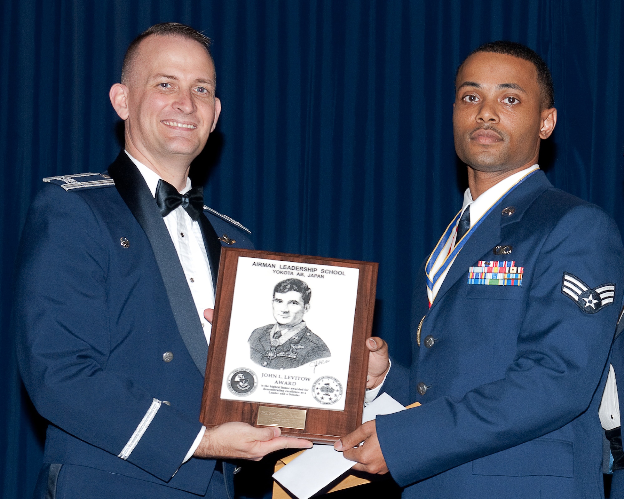 YOKOTA AIR BASE, Japan -- Senior Airman Randall Vaughn (right), 374th Operations Support Squadron, receives the John L. Levitow Award from Col. Bill Knight (left), 374th Airlift Wing commander, during the Airman Leadership School graduation ceremony at Yokota Air Base, Japan, May 3, 2012. The John L. Levito Award is the highest professional military education award given to enlisted members. (U.S. Air Force photo/Osakabe Yasuo) 
