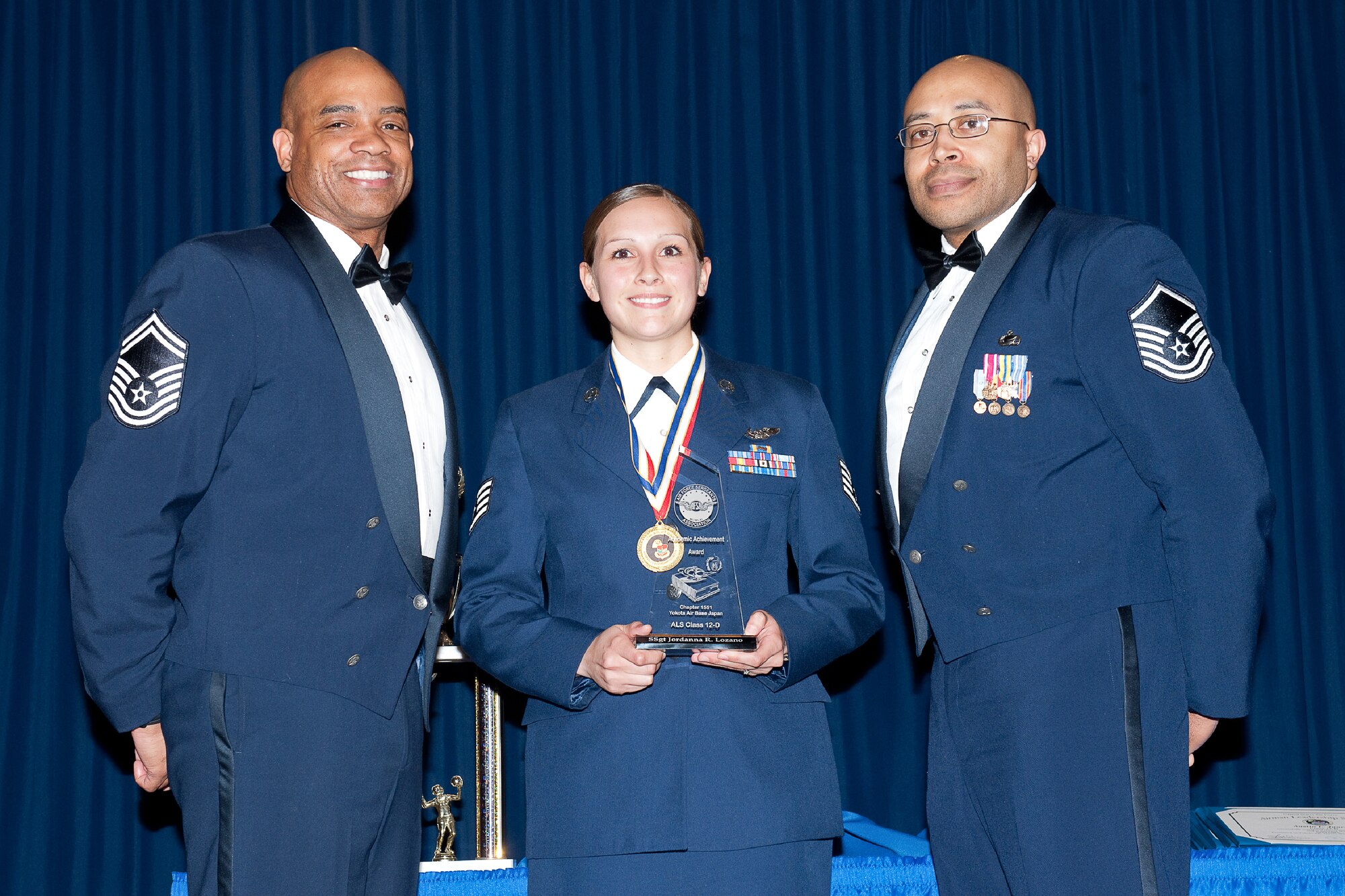 YOKOTA AIR BASE, Japan -- Staff Sgt. Jordanna Lozano (center), 36th Airlift Squadron, is awarded the Academic Award during the Airman Leadership School Class 12-Delta graduation ceremony at Yokota Air Base, Japan, May 3, 2012. Senior Master Sgt. Vincent Burrell (left), United States Forces Japan, and Master Sgt. Tommy Reid (right), 374th Maintenance Operations Squadron, representatives of the Air Force Sergeants Association, presented the award to Lozano during the ceremony. (U.S. Air Force photo/Osakabe Yasuo)  