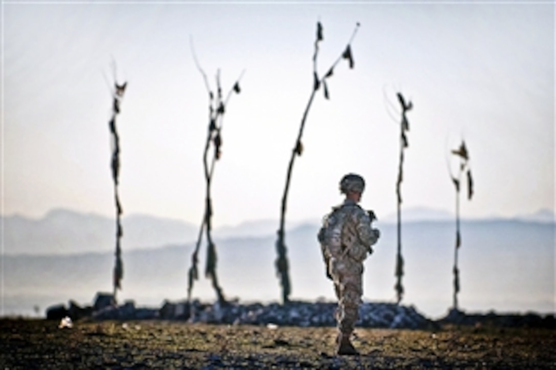 U.S. Army Spc. Jon Saladin walks past an Afghan graveyard during a combined patrol clearing operation in Afghanistan's Ghazni province, April 30, 2012. Saladin is assigned to the 82nd Airborne Division’s 2nd Battalion, 504th Parachute Infantry Regiment, 1st Brigade Combat Team.