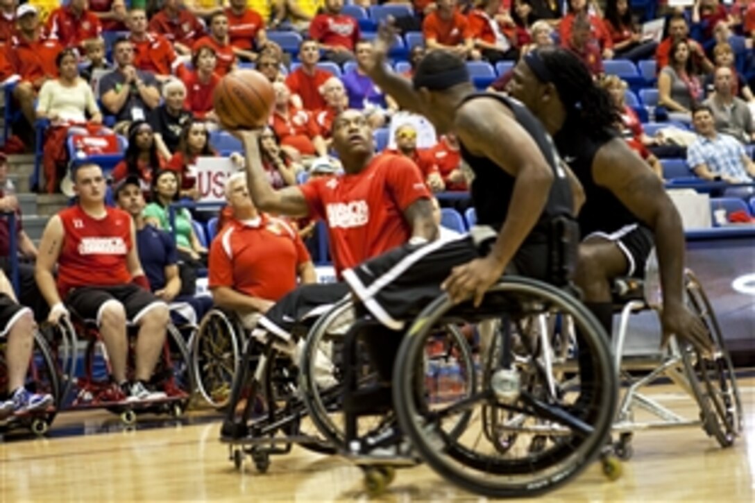 Marine Corps Cpl. Anthony McDaniel defends a charge by two Army players during the Marine Corps versus Army wheelchair basketball game of the 2012 Warrior Games at the U.S. Air Force Academy in Colorado Springs, Colo., May 3, 2012. 