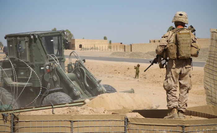 Sergeant Timothy Brookshire, a combat engineer serving with Engineers Platoon, 2nd Battalion, 9th Marine Regiment, provides security over watch as his Marines construct new fortified walls around the base’s perimeter here May 4, 2012. Combat engineers have torn down some of the fortified walls to shrink the base’s perimeter. The Marines plan to reduce their base’s guard posts in half by the end of their seven-month deployment. Brookshire is a Homer, Ga., native.