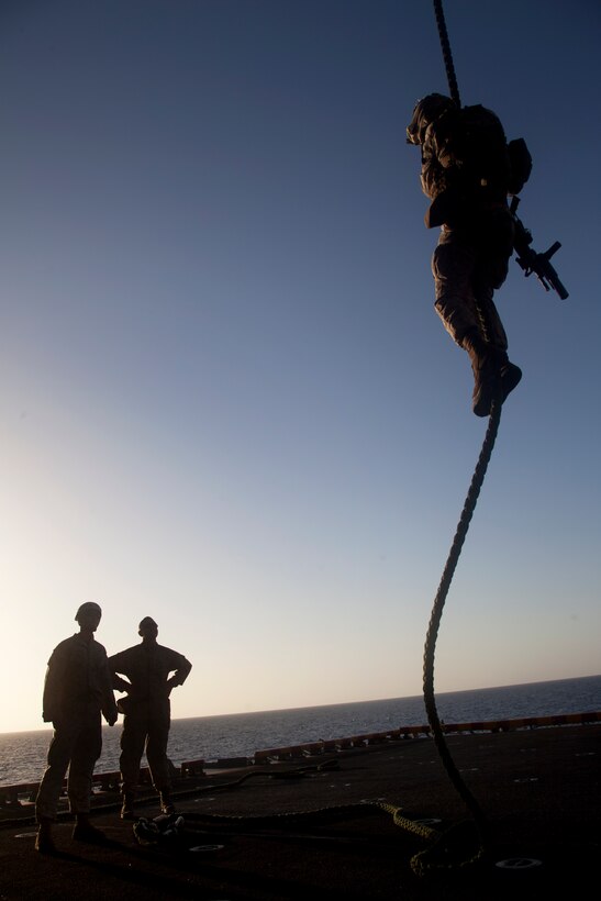 A Marine descends 35 feet down a thick, plaited rope rigged to a helicopter parked aboard USS Makin Island here May 4. The Marine serves with Battalion Landing Team 3/1, the ground combat element for the 11th Marine Expeditionary Unit. The unit is deployed as part of the Makin Island Amphibious Ready Group, currently a U.S. Central Command theater reserve force. The group is providing support for maritime security operations and theater security cooperation efforts in the U.S. Navy's 5th Fleet area of responsibility.