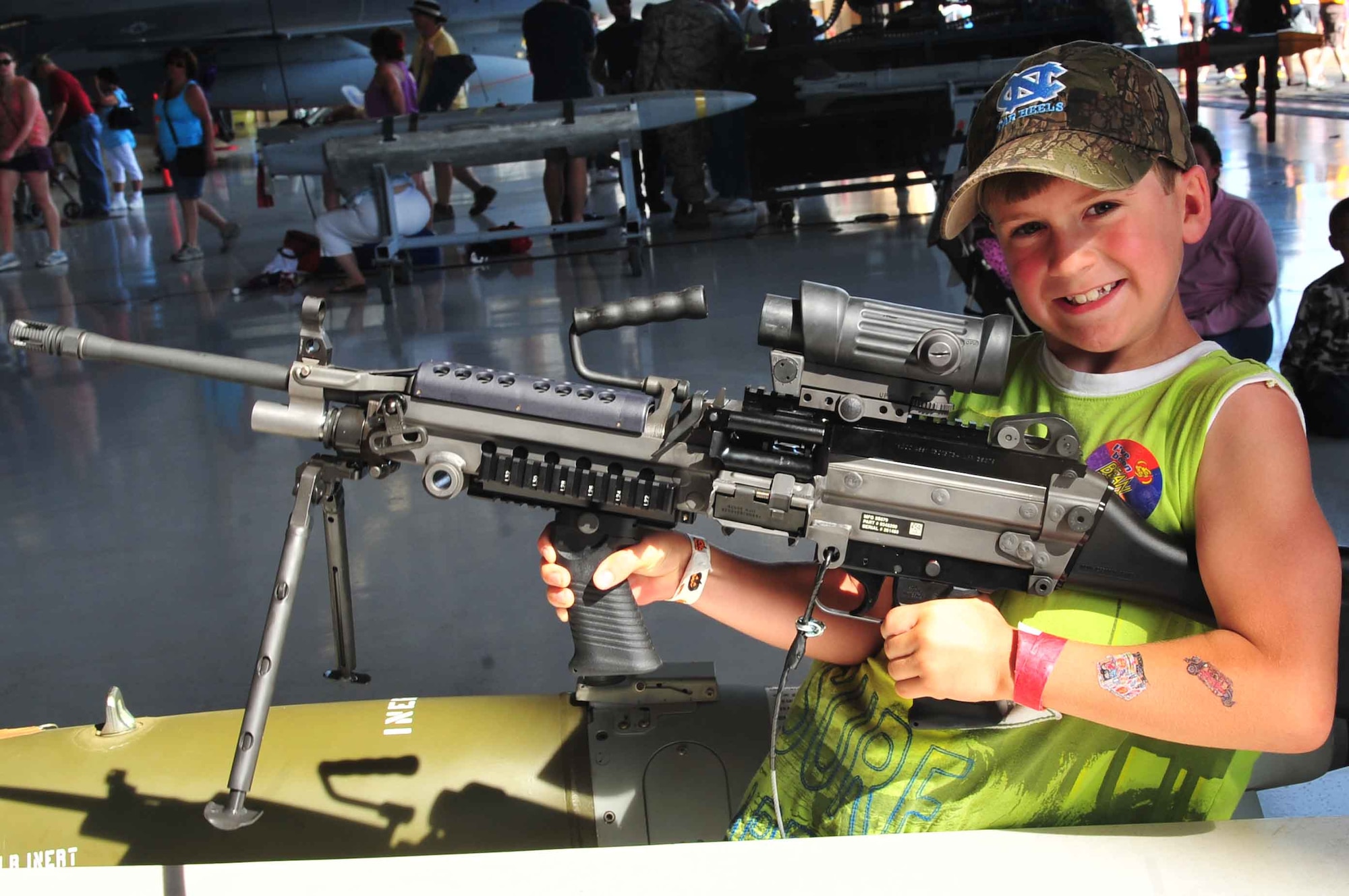 Matthew Cutbush, son of Jennifer Holder, holds a M249 squad automatic weapon on display while attending the Shaw Air Expo held at Shaw Air Force Base, S.C., May 5, 2012. The expo included live music from the Blue Aces, food vendors, the U.S. Army Golden Knights and the U.S. Air Force Thunderbirds. (U.S. Air Force photo by Airman 1st Class Ashley L. Gardner/ Released)