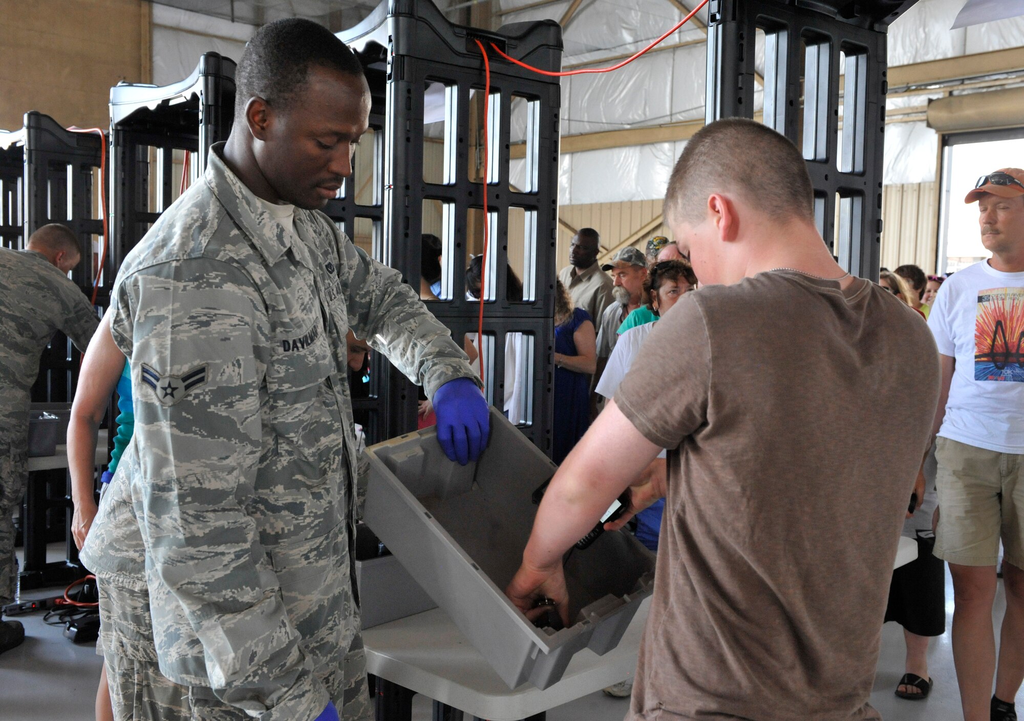 U.S. Air Force Airman 1st Class Calebe Davilmar, 20th Civil Engineer Squadron electrical apprentice, scans a man through a metal detector as he enters Shaw Air Expo at Shaw Air Force Base, S.C., May 5, 2012. More than 20 security forces' augmenties from different squadrons of the 20th Fighter Wing performed security checks at the entrance of the Shaw Air Expo during the first day of the air show. The Shaw Air Expo will be held both May 5 and 6 and is free to the general public.  (U.S. Air Force photo by Senior Airman Amber E. N. Jacobs/Released) 