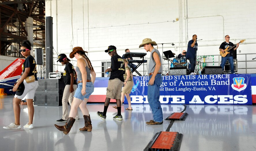 Anastasia Eubanks (front left center) and her brother Alexander Eubanks (center), both from Cross Anchor, S.C., teach members of the Irmo Air Force Junior Reserve Officer Training Corps (JROTC) how to line dance during a Blue Aces performance during the Shaw Air Expo at Shaw Air Force Base, S.C., May 5, 2012. The Blue Aces are a fast-paced band with productions that encompass a wide variety of musical styles. The Blue Aces performed in the main hangar of the Shaw Air Expo throughout the day. The Shaw Air Expo will be held both May 5 and 6 will feature over 28 static displays and 19 performers.(U.S. Air Force Photo by Senior Airman Amber E. N. Jacobs/Released)