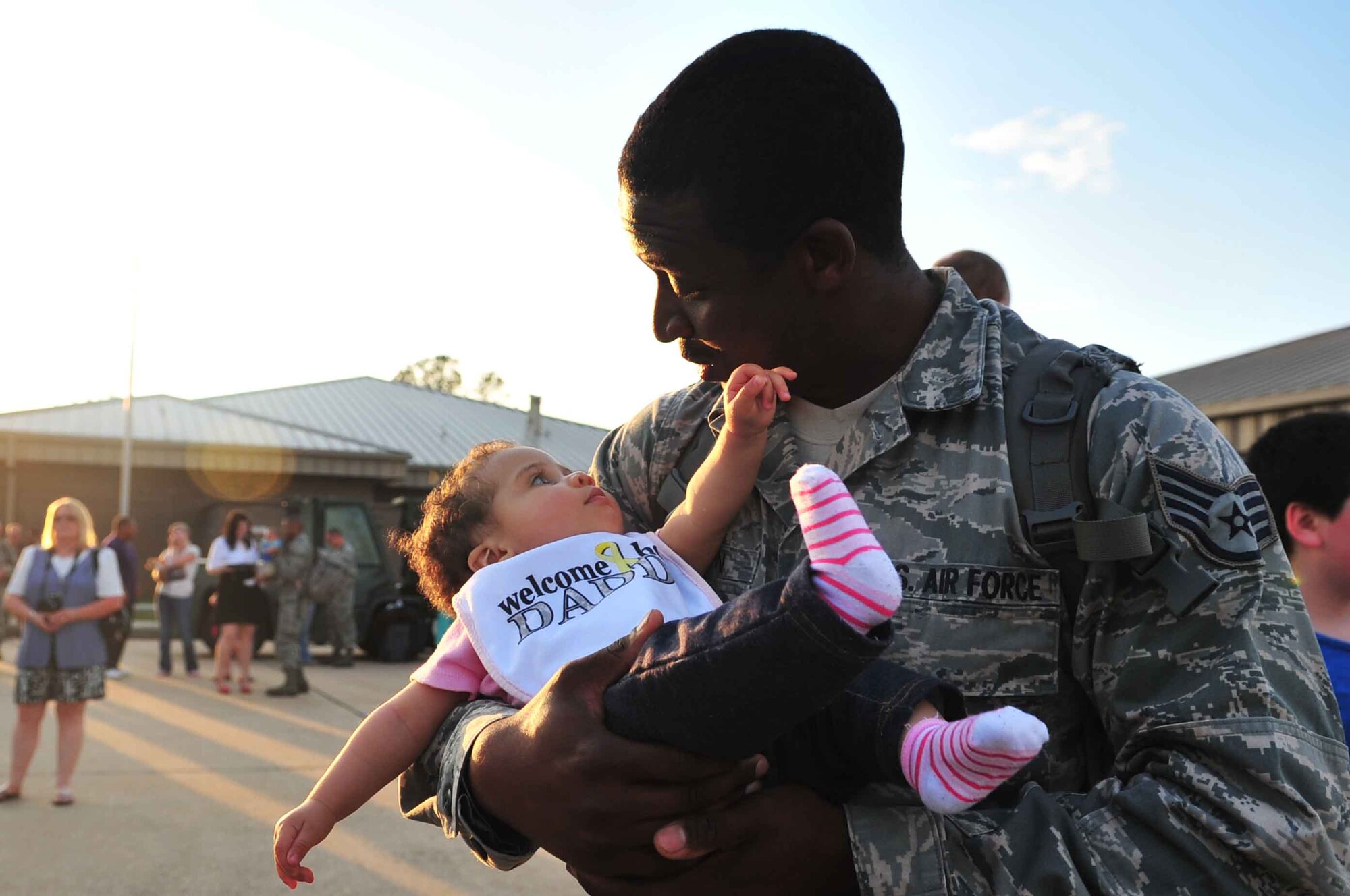 U.S. Air Force Staff Sgt. Joseph Holton, 20th Equipment Maintenance Squadron, holds his daughter Joy Holton after arriving at Shaw Air Force Base, S.C., May 4, 2012. Holton returned home with 234 members of the 55th Expeditionary Fighter Squadron after completing a four-month deployment at Kunsan AB, Republic of Korea. (U.S. Air Force photo by Airman 1st Class Ashley L. Gardner/ Released)