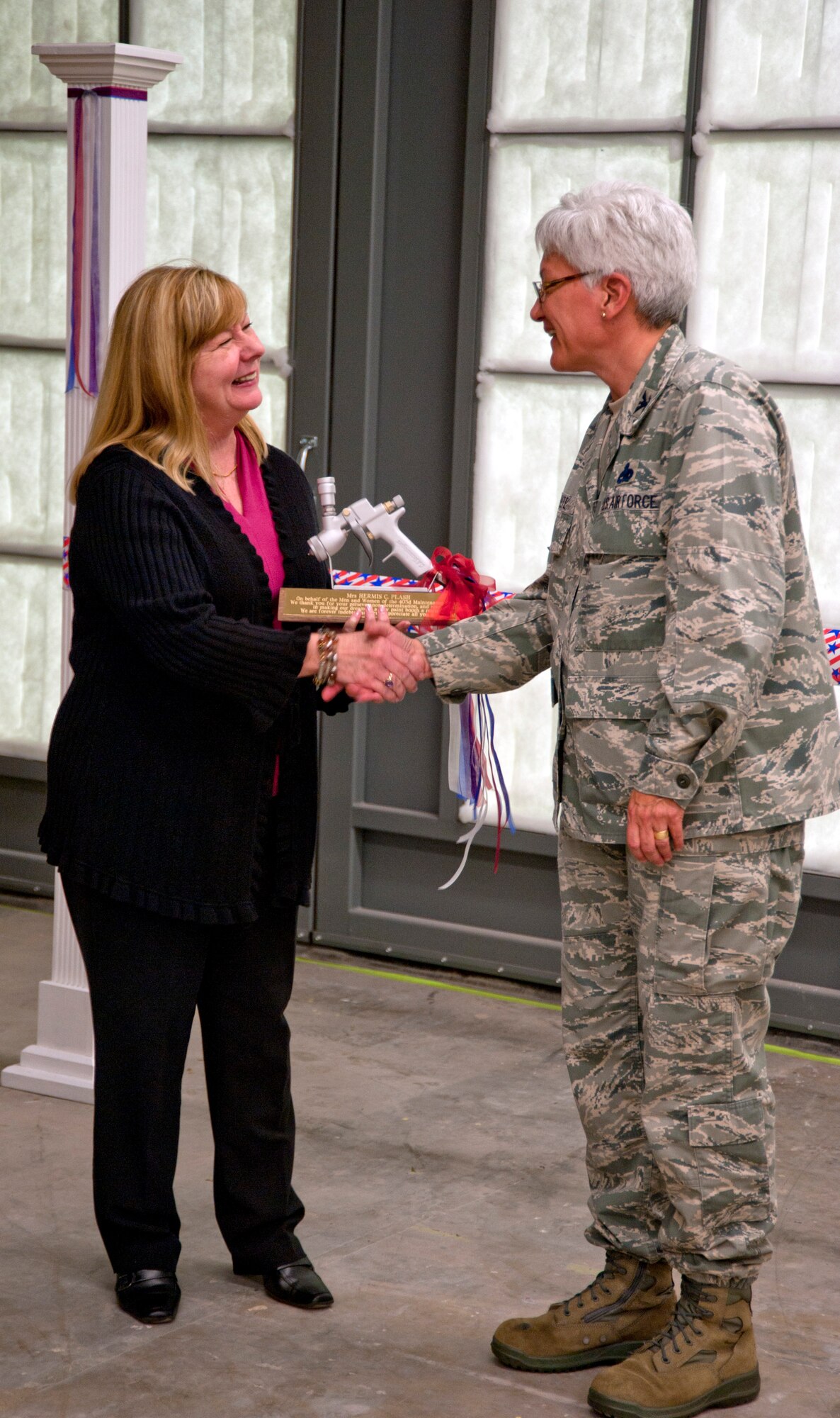 Col. Anna Schulte, 403rd Maintenance Group commander, presents Hermis Plash with a token of appreciation for her dedication and commitment to obtaining the Wing's new paint booth. Plash, along with Chief Master Sgt. Vincent Armata started the process to obtain a new paint booth in 2000. The original paint booth was 27 years old and failed to meet requirements. In September 2010, the equipment was deemed non-operational and forced the Wing's structural shop to go on temporary duty to Duke Field in order to accomplish the required painting of landing gear rims, break housings, and nose landing gear tow fitting assemblies. The new paint booth not only eliminates the need to travel to Duke Field, it allows the Wing to meet corrosion contral requirements for over 200 pieces of aircraft support equipment.