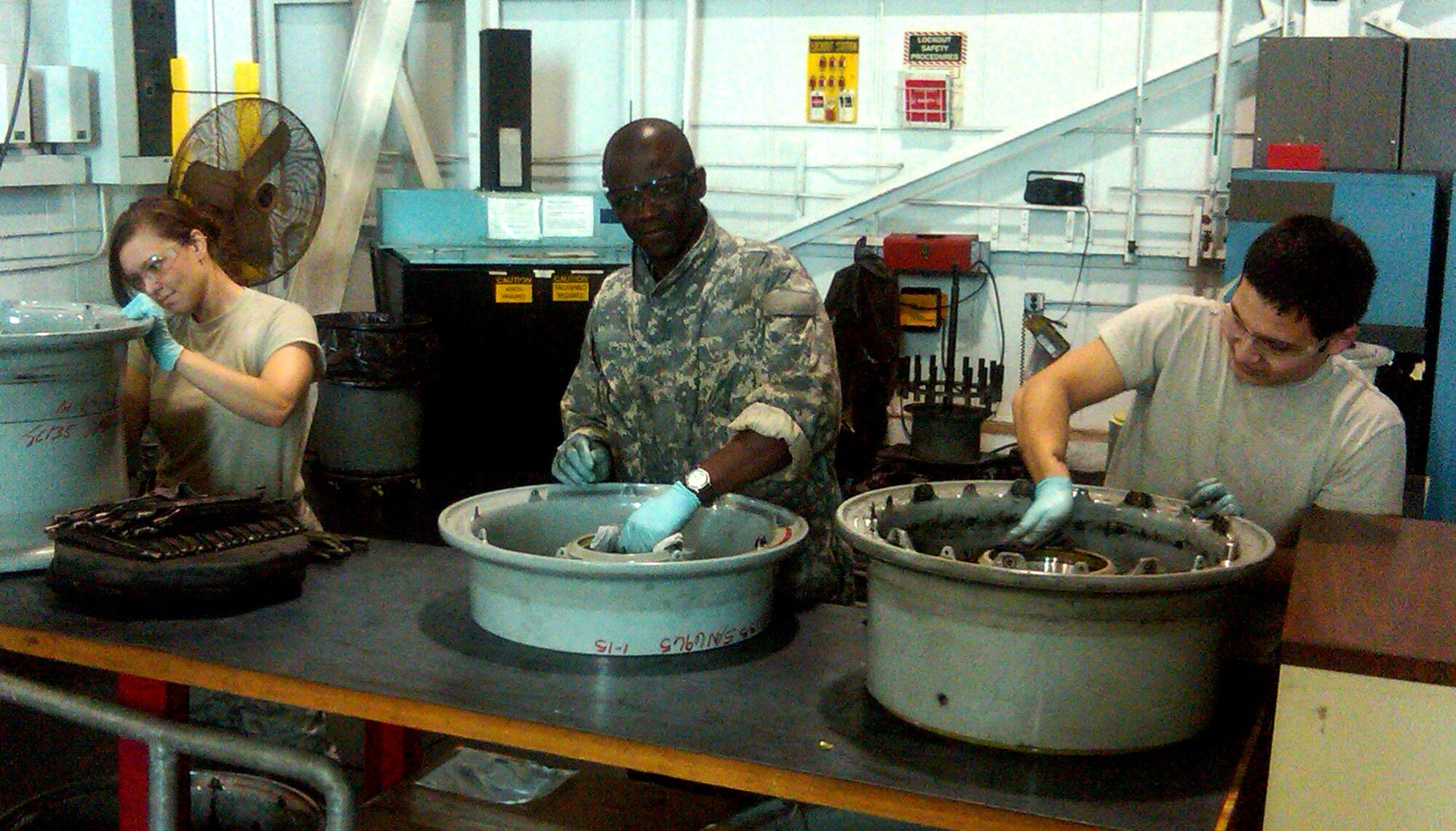 Tech. Sgt. Kimberly Lingle (left), Senior Airman Wilner LaGuerre (center) and Airman 1st Class Mark Flores of the 507th Maintenance Group refurbish wheels for one of the 507th Air Refueling Wing's KC-135 Stratotanker aircraft at Tinker Air Force Base, Okla., on April 15, 2012.  The Airmen are assigned to the 507th MXG's aero repair shop.
