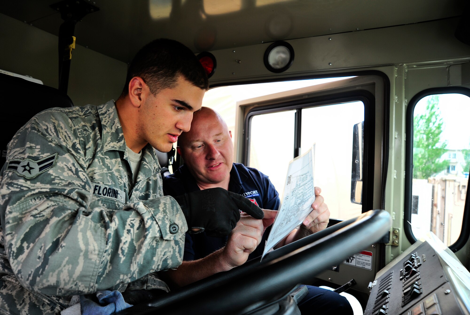 Airman 1st Class Dominic Florini and Mark Williams conduct turn-over training in a fire truck April 27, 2012, at the Transit Center at Manas, Kyrgyzstan. Florini is a 376th Expeditionary Civil Engineer Squadron fire fighter deployed here from Barksdale Air Force Base, La. Williams is a Sally Port Emergency Services contractor and is originally from Kimble, Neb. (U.S. Air Force photo/Staff Sgt. Angela Ruiz)