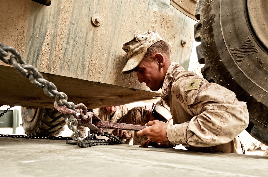 Lance Cpl. Travis M. Stewart, motor vehicle operator, Alpha Company, Combat Logistics Battalion 4, 1st Marine Logistics Group (Forward), tightens the chains holding down a Multi-Mission Vehicle at Patrol Base Habib, May 5. The MMV was one of the pieces of equipment that was retrograded by CLB-4 from PB Habib in preparation for the departure of Marines with 2nd Battalion, 5th Marine Regiment from the patrol base.