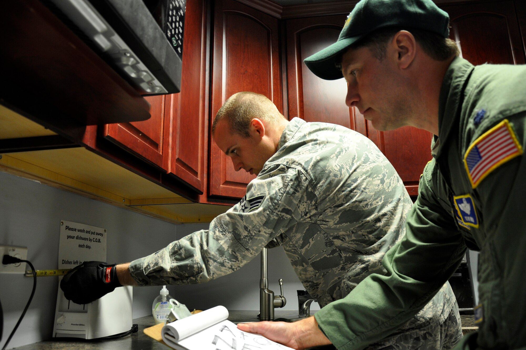 Senior Airman Ron Krotzer, a 446th CES electrician apprentice, ensures the upgrades he made are within code.  Lt. Col. Kevin Welin, 446th AW chief of safety oversees and inspects his work to verify code and safety standards are met.  Krotzer works under the supervision of his trainer, Master Sgt. Dwayne Lee, 446th CES electrician, who has been a journeyman electrician with the International Brotherhood of Electrical Workers Union Local 76 for the past seven years.  Performing the work in house both saves money and allows the apprenctice airmen to get valuable on-the-job training they need to become fully qualified. (U.S. Air Force photo by Master Sgt. Jake Chappelle)
