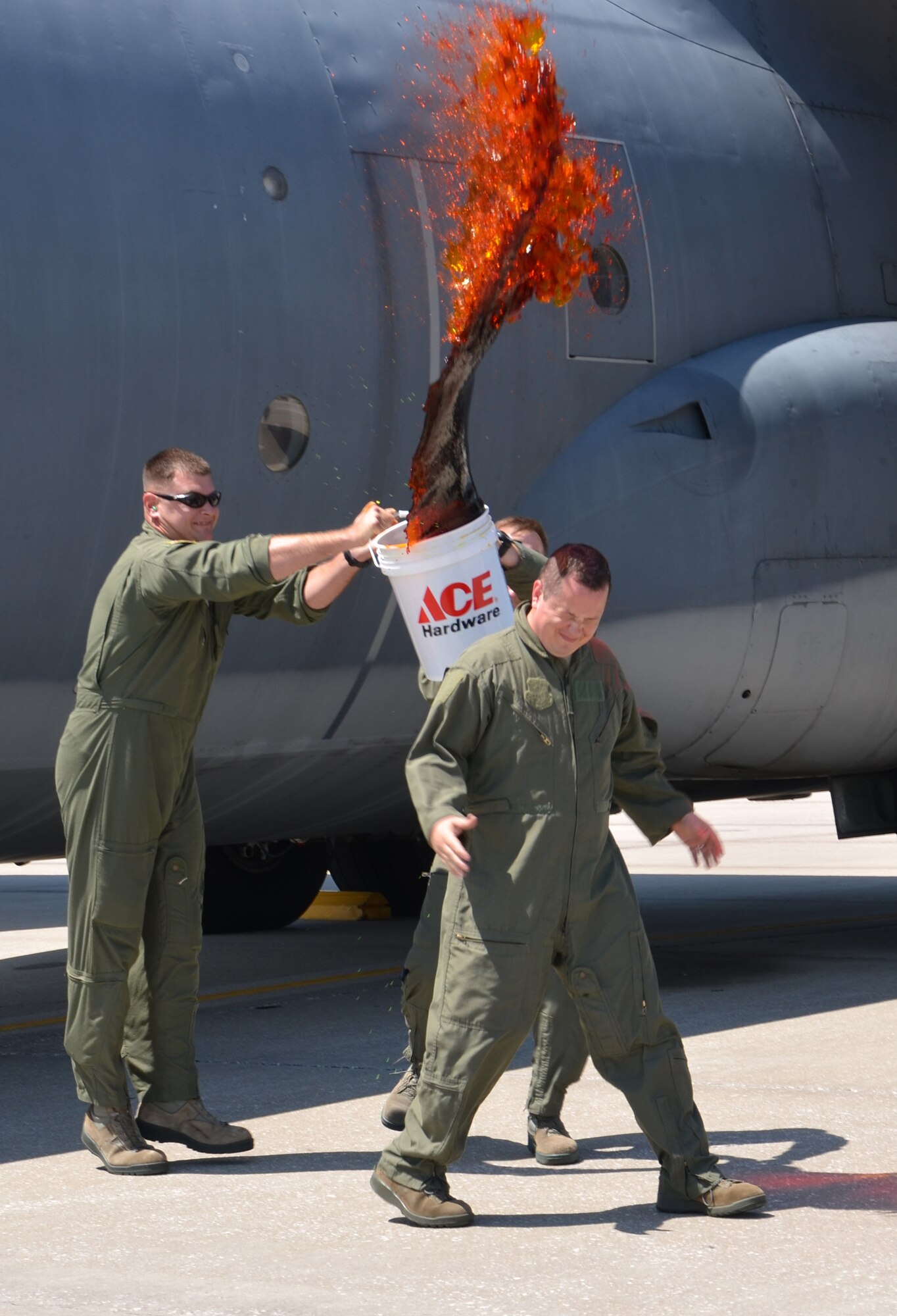 Master Sgt. Rob Grande, radio operator shop chief, 39th rescue squadron, Patrick Air Force Base, Fla., braces himself for a shower of orange sea-dyed water. Rob Grande flew on one of the 920th Rescue Wing's HC-130P/N King aircraft for the last time as a member of the unit. (U.S. Air Force photo/Senior Airman Natasha Dowridge)