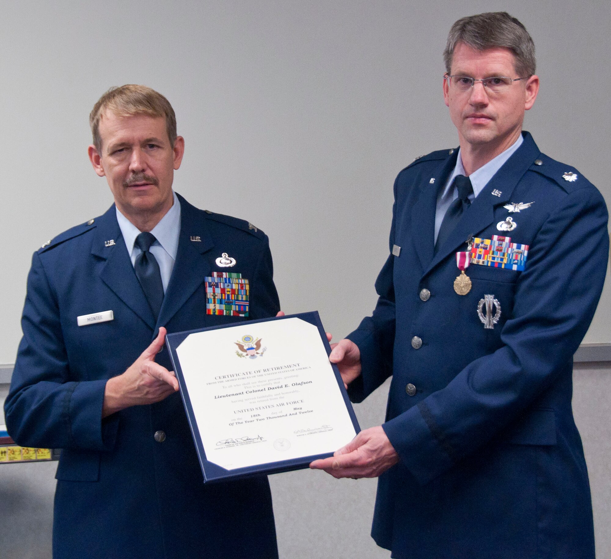 Colonel Mark Montee, Director of Intelligence and Reconnaissance Command, presents  Lt. Col. David Olafson, Senior Intelligence Officer 934th Operations Squadron, with his retirement certificate, May 6, 2012. (US Air Force Photo/Tech Sgt. Jim Loehr)