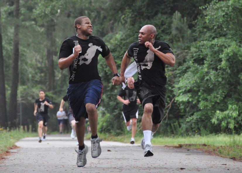Members of the 916th Air Refueling Wing Training Flight push each other to the finish line during the wing's semi-annual Warrior Run held on Sunday, May 6, 2012. (USAF photo by Master Sgt. Wendy Lopedote, 916ARW, released)