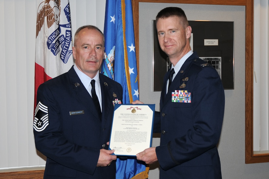 On the occasion of his retirement from the 132nd Fighter Wing (132FW), Des Moines, Iowa, Chief Master Sgt. Tom Montgomery (left), is awarded the Meritorious Service Medal, given to him by Col. Mark Chidley (right), 132FW Mission Support Group Commander, in the Wing Classroom of the 132FW on May 5, 2012.  (National Guard photo/Staff Sgt. Linda E. Kephart)(Released)