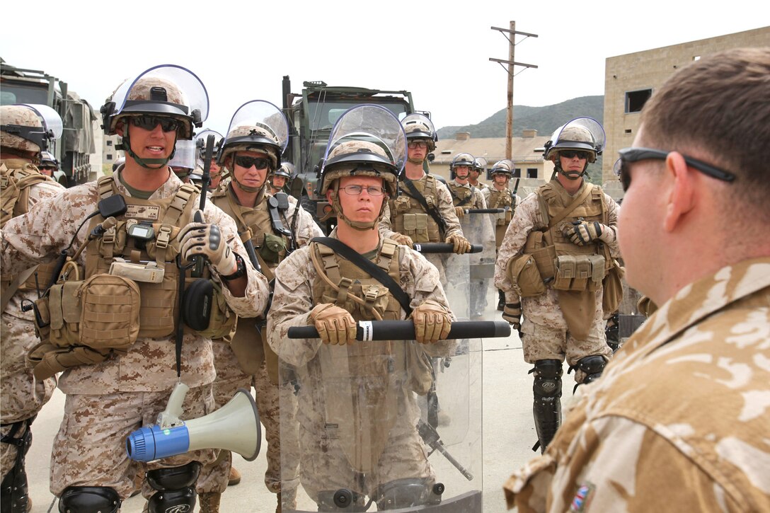 Second Lt. Zachary W. Peters (left), Lima Company, Battalion Landing Team 3/5, 15th Marine Expeditionary Unit, negotiates with the leader of a role-played riot during riot control training aboard Camp Pendleton, Calif., May 6. The weeklong training exercise teaches Marines to deal with all levels of violence up to and including terrorist attacks. The unit is training to become the MEU’s designated non-lethal response unit for their upcoming deployment.