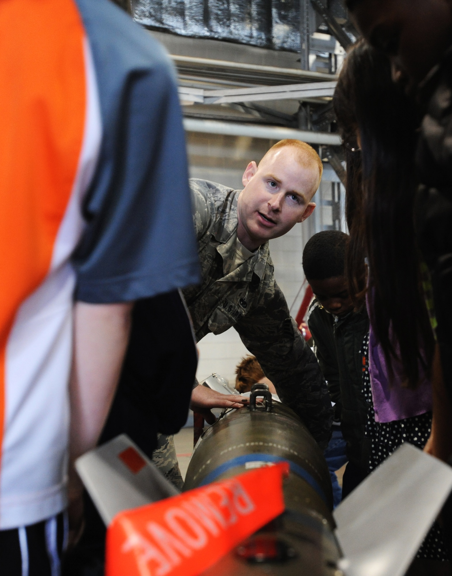 U.S. Air Force Staff Sgt. Branden Paddock, 35th Maintenance Group squadron load crew chief, briefs third grade students from Sollars Elementary School on some interesting facts about military joint direct attack munitions in Hangar 911 at Misawa Air Base, Japan, May 3, 2012. The purpose of the static display was to give children a chance to further immerse themselves into the military environment. (U.S. Air Force photo by Airman Kenna Jackson/Released)