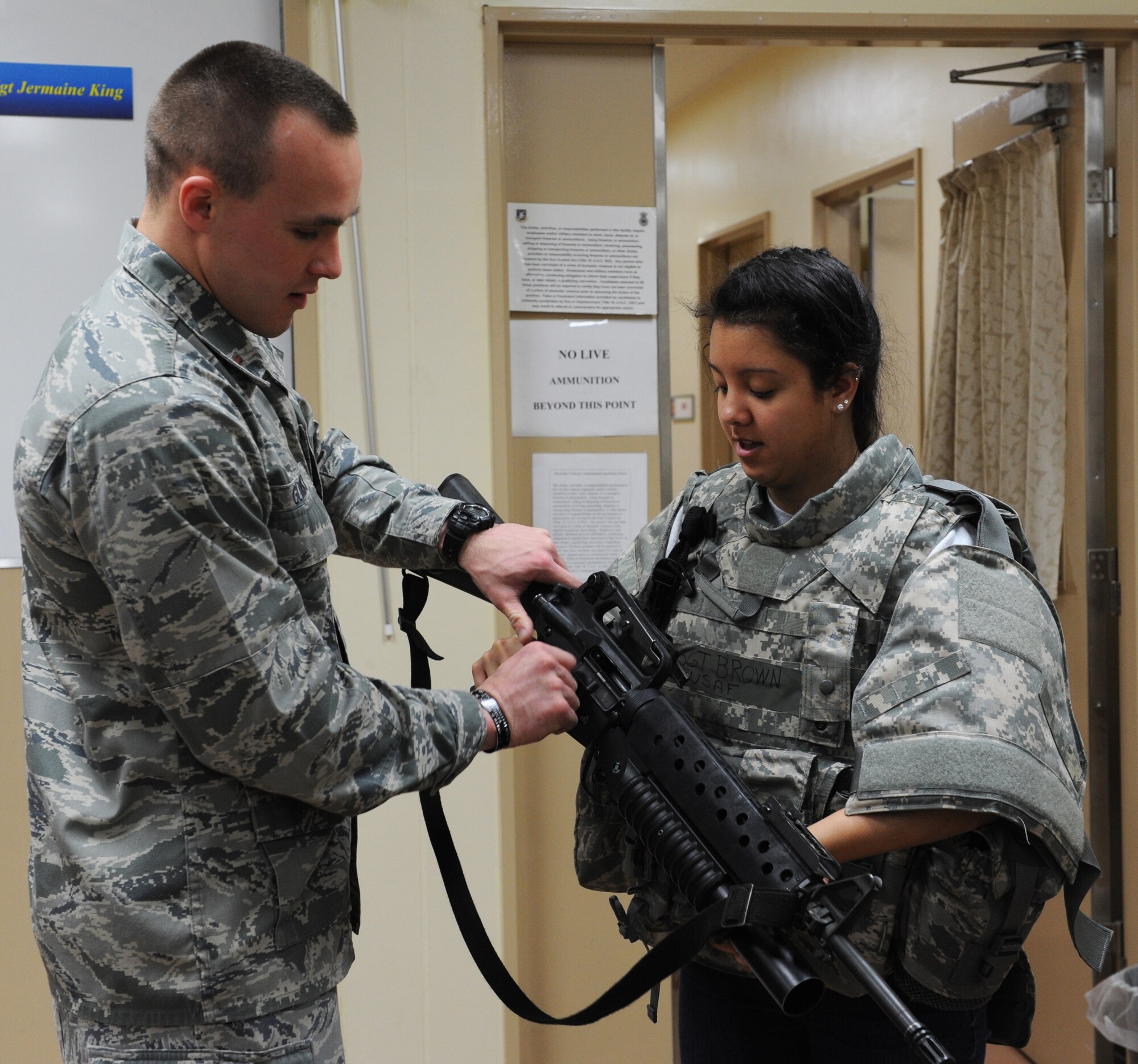 U.S. Air Force 2nd Lt. Harlan Glinski, 35th Security Forces Squadron logistics and resources officer, shows the daughter of Tech. Sgt. Kristopher Audette, 35th Maintenance Group dedicated fuels shop quality assurance inspector, an M16A2 rifle with an M203 grenade launcher during Edgren High School's Junior Reserve Officer Training Corps visit to the small arms range at Misawa Air Base, Japan, May 4, 2012. The visiting students looked at weapons and tried on equipment that their parents would wear while in a deployed environment to better understand deployment preparation. (U.S. Air Force photo by Airman 1st Class Kia Atkins/Released)