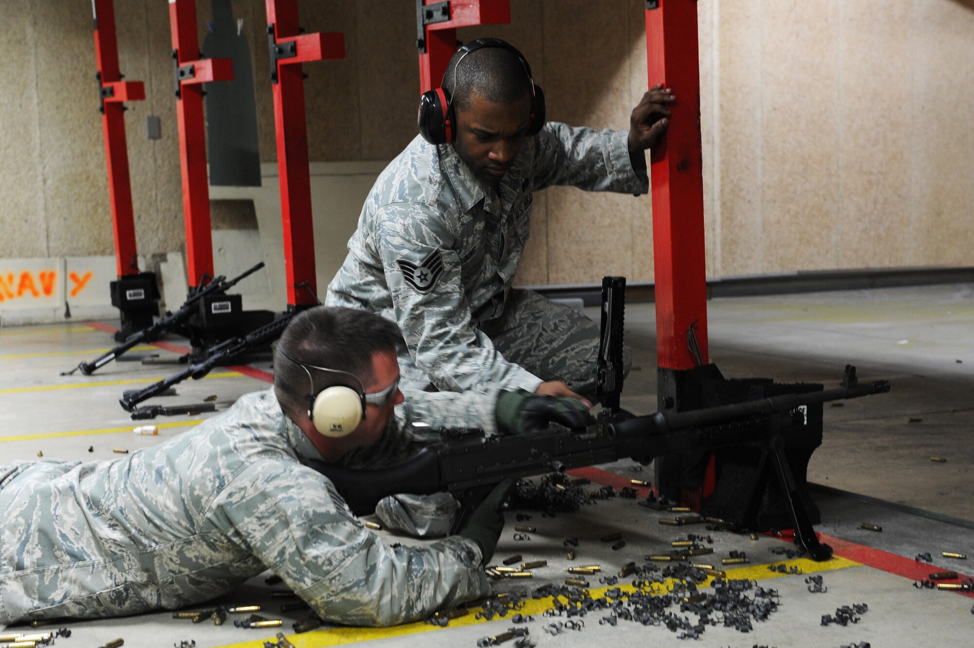 U.S. Air Force Staff Sgt. Jordan Fisher, left, 35th Security Forces Squadron combat arms instructor, and Staff Sgt. Jermaine King, 35 SFS NCO in charge combat arms, perform a weapons check after firing the M240B machine gun during a weapons firing demonstration for students from Edgren High School's Junior Reserve Officer Training Corps at the small arms range at Misawa Air Base, Japan, May 4, 2012. Weapons checks are performed to ensure the weapon is clear of all ammunition and links. The purpose of the visit was to help the students get a better understanding of some of the training their parents have to do before deploying. (U.S. Air Force photo by Airman 1st Class Kia Atkins/Released)