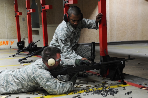 U.S. Air Force Staff Sgt. Jordan Fisher, left, 35th Security Forces Squadron combat arms instructor, and Staff Sgt. Jermaine King, 35 SFS NCO in charge combat arms, perform a weapons check after firing the M240B machine gun during a weapons firing demonstration for students from Edgren High School's Junior Reserve Officer Training Corps at the small arms range at Misawa Air Base, Japan, May 4, 2012. Weapons checks are performed to ensure the weapon is clear of all ammunition and links. The purpose of the visit was to help the students get a better understanding of some of the training their parents have to do before deploying. (U.S. Air Force photo/Airman 1st Class Kia Atkins/Released) 

