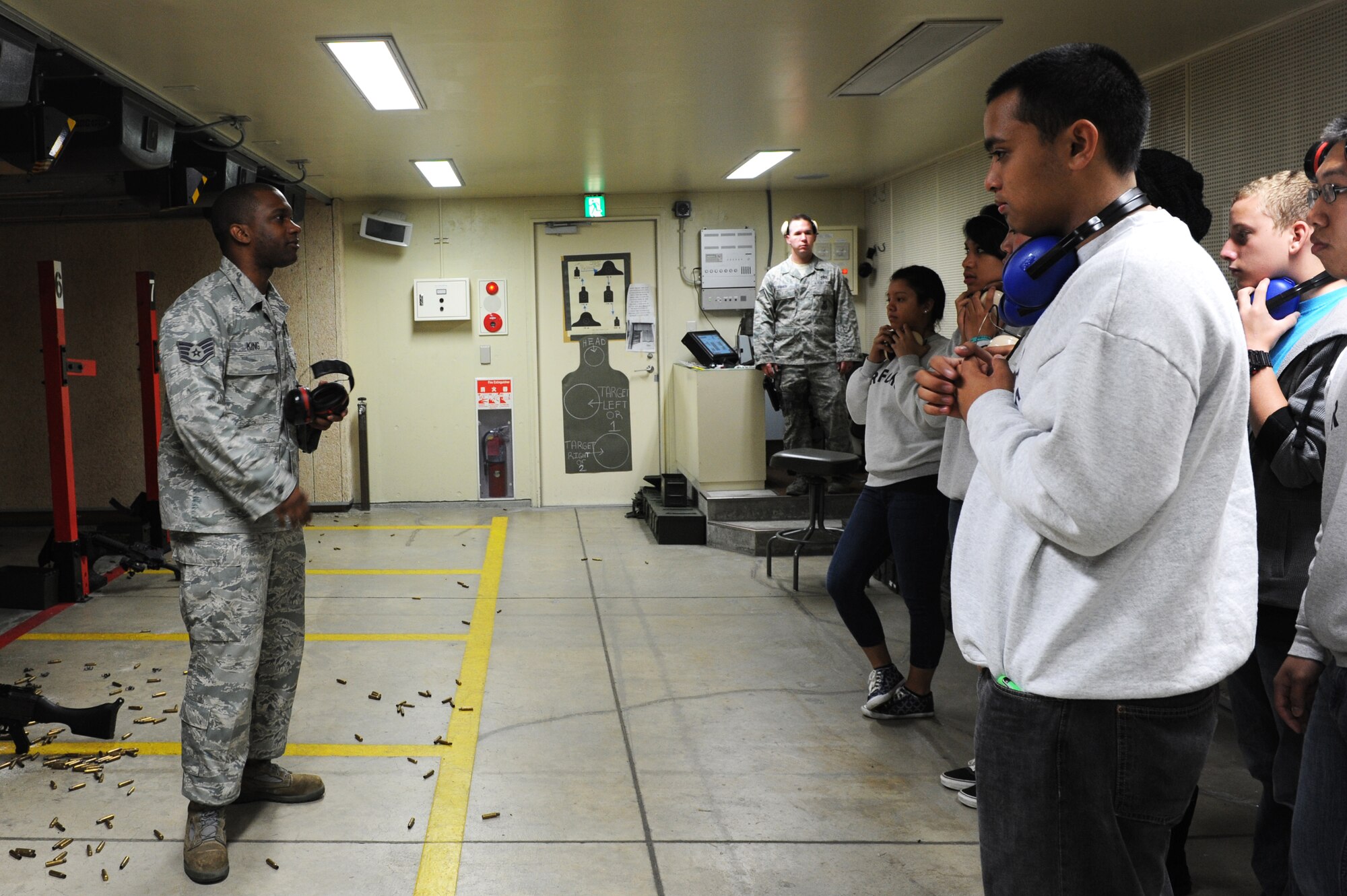 U.S. Air Force Staff Sgt. Jermaine King, left, 35th Security Forces Squadron NCO in charge combat arms, briefs students from Edgren High School's Junior Reserve Officer Training Corps on weapons safety before a weapons firing demonstration at the small arms range at Misawa Air Base, Japan, May 4, 2012. During training, students received a better understanding of the weapons training their parents have to go through before deploying. (U.S. Air Force photo by Airman 1st Class Kia Atkins/Released)
