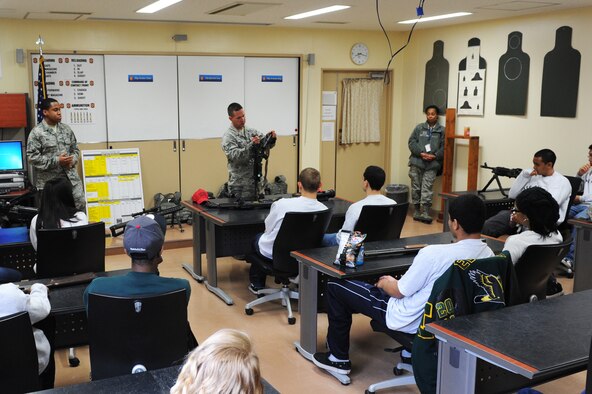 U.S. Air Force Staff Sgt. Jordan Fisher, center, 35th Security Forces Squadron combat arms instructor, takes apart an M4 carbine during Edgren High School's Junior Reserve Officer Training Corps visit to the small arms range at Misawa Air Base, Japan, May 4, 2012. The visit helped the students better understand what their parents have to do before deploying. (U.S. Air Force photo/Airman 1st Class Kia Atkins/Released) 
