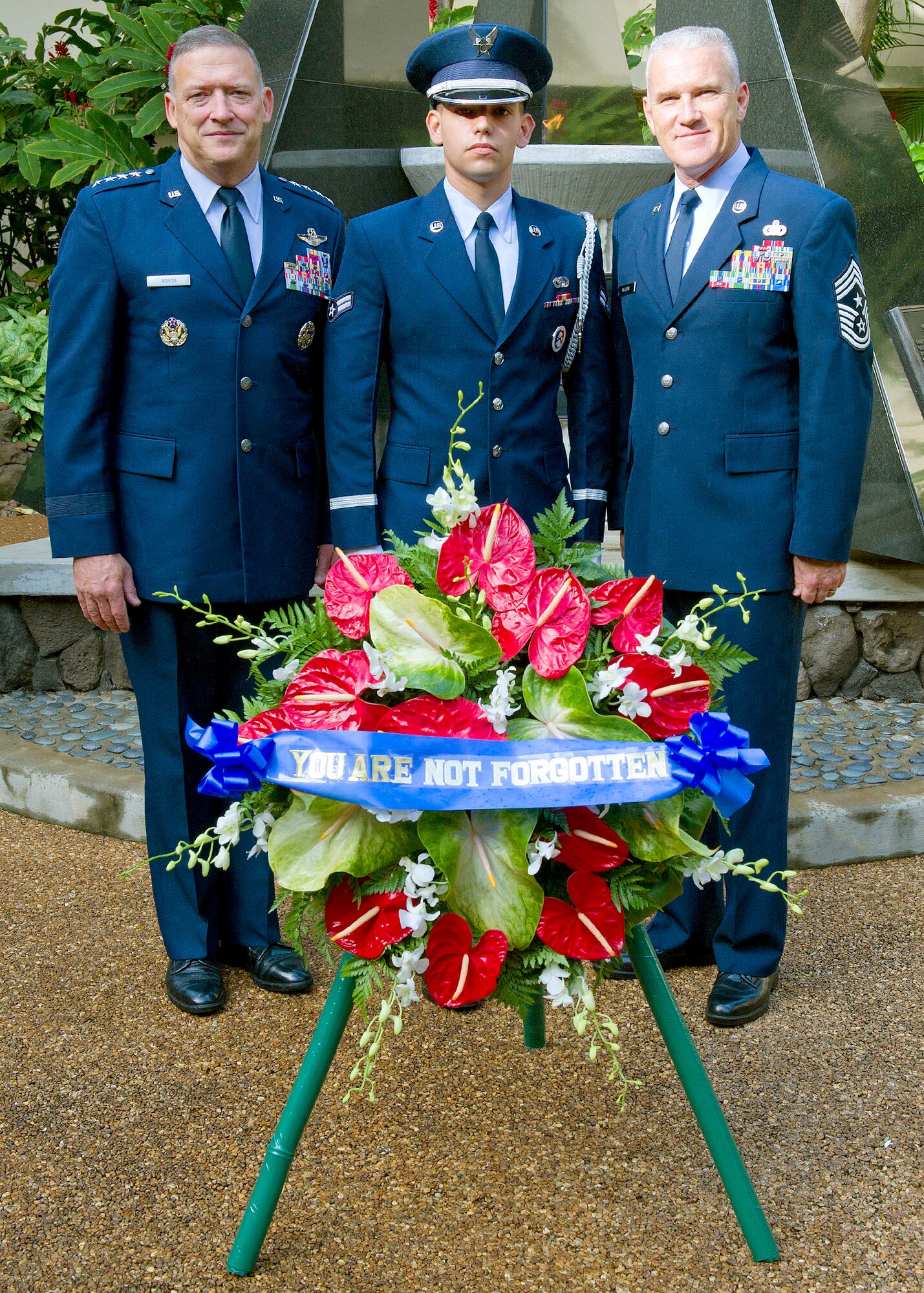 Gen. Gary North, Pacific Air Forces commander, Airman First Class Jonathan Timmons, from the Joint Base Pearl Harbor-Hickam Honor Guard, and Command Chief Master Sgt. Brooke McLean pose for a group photo at the Courtyard of Heroes, Headquarters Pacific Air Forces, Joint Base Pearl Harbor Hickam, Hawaii, April 23, 2012. The general, command chief and PACAF’s outstanding Airmen of the year presided over the ceremony honoring those who died at Hickam Field, Dec. 7, 1941. (U. S. Air Force photo/Tech. Sgt. Jerome S. Tayborn)