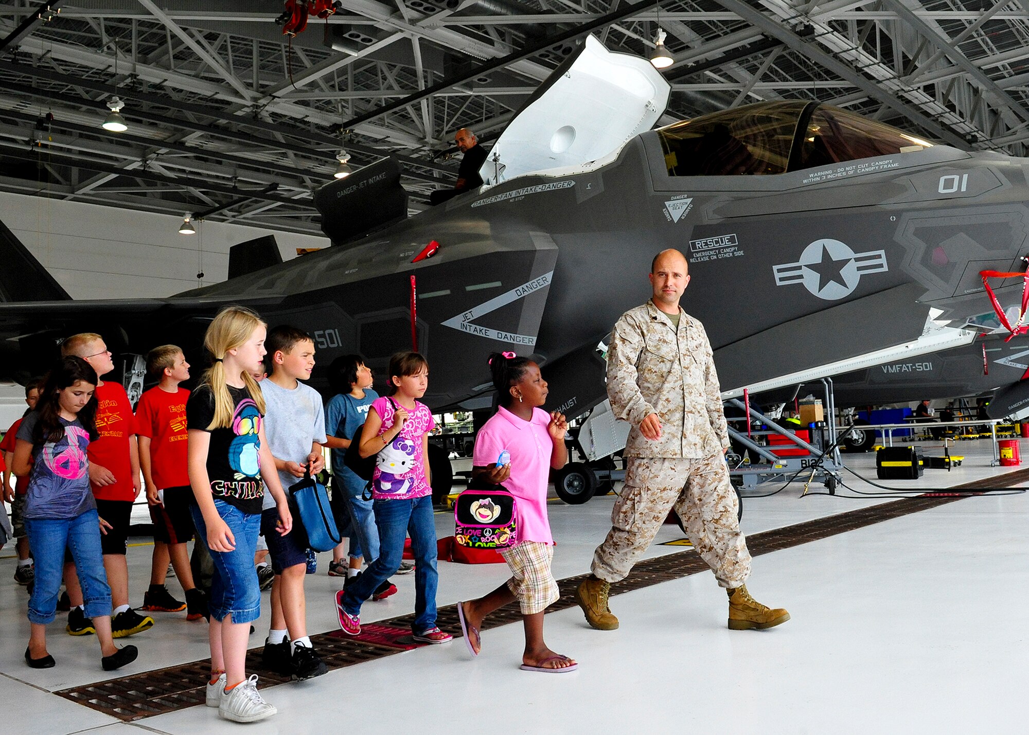 Sgt. Jordan Dennis, of Marine Fighter Attack Squadron-501, escorts  students on a tour of the F-35B inside the Marine Corps hangar, capping off their participation in 17th annual Marsville event May 4 at Eglin Air Force Base, Fla.  The Marsville program is designed to inspire students to enter the highly demanding career fields of science, technology, engineering and math. (U.S. Air Force photo/Randy Gon)