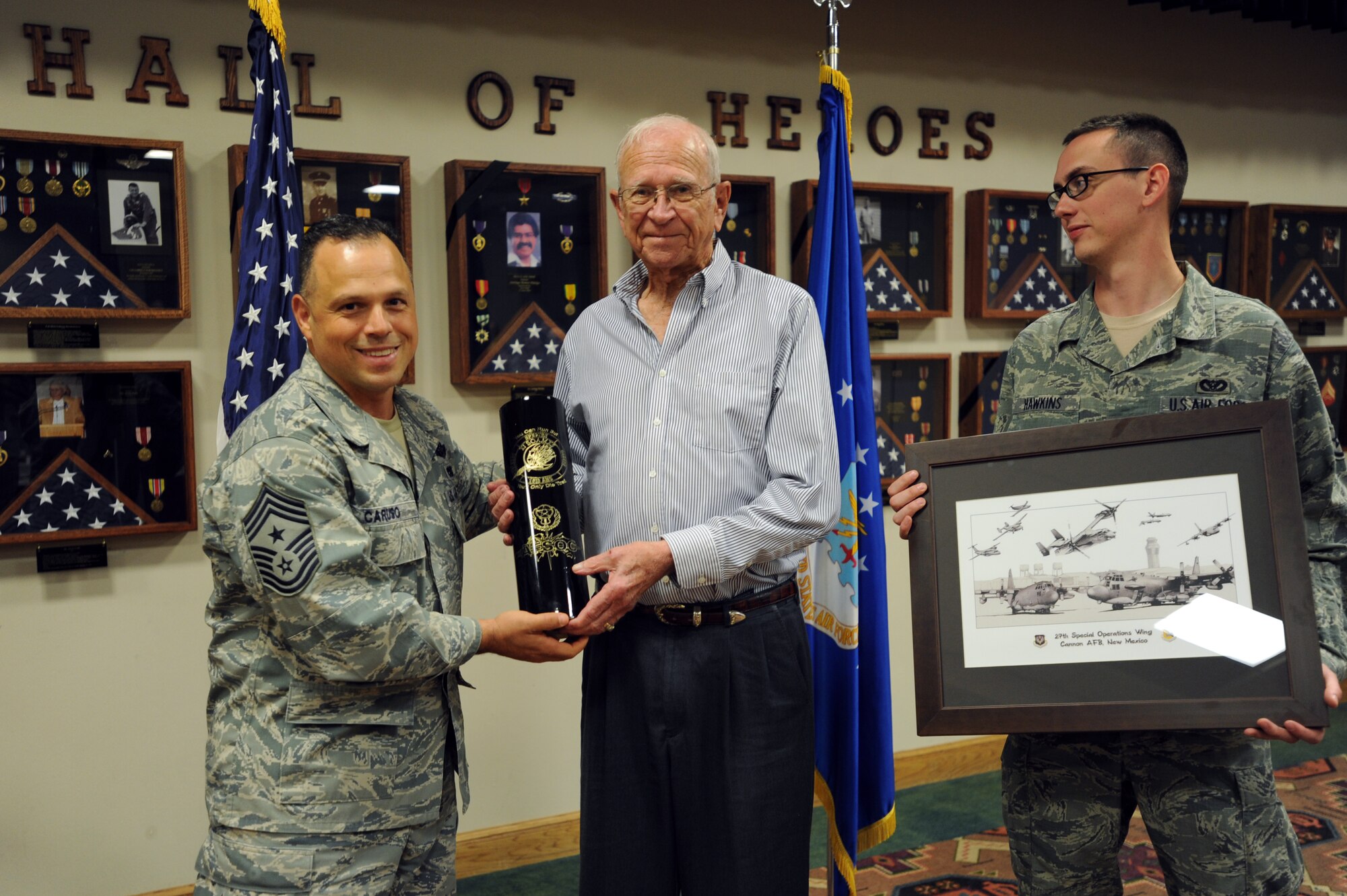 U.S. Air Force Chief Master Sgt. Matthew Caruso, 27th Special Operations Wing command chief, and Staff Sgt. Dustin Hawkins, 27th Special Operations Civil Engineer Squadron electrical power production journeyman, award Dan McKinney with tokens of appreciation during a Hall of Heroes recognition ceremony at Cannon Air Force Base, N.M., April 26, 2012. McKinney served in the Korean War, where he survived being held as a prisoner of war for two years.  (U.S. Air Force photo by Senior Airman Jette Carr)
