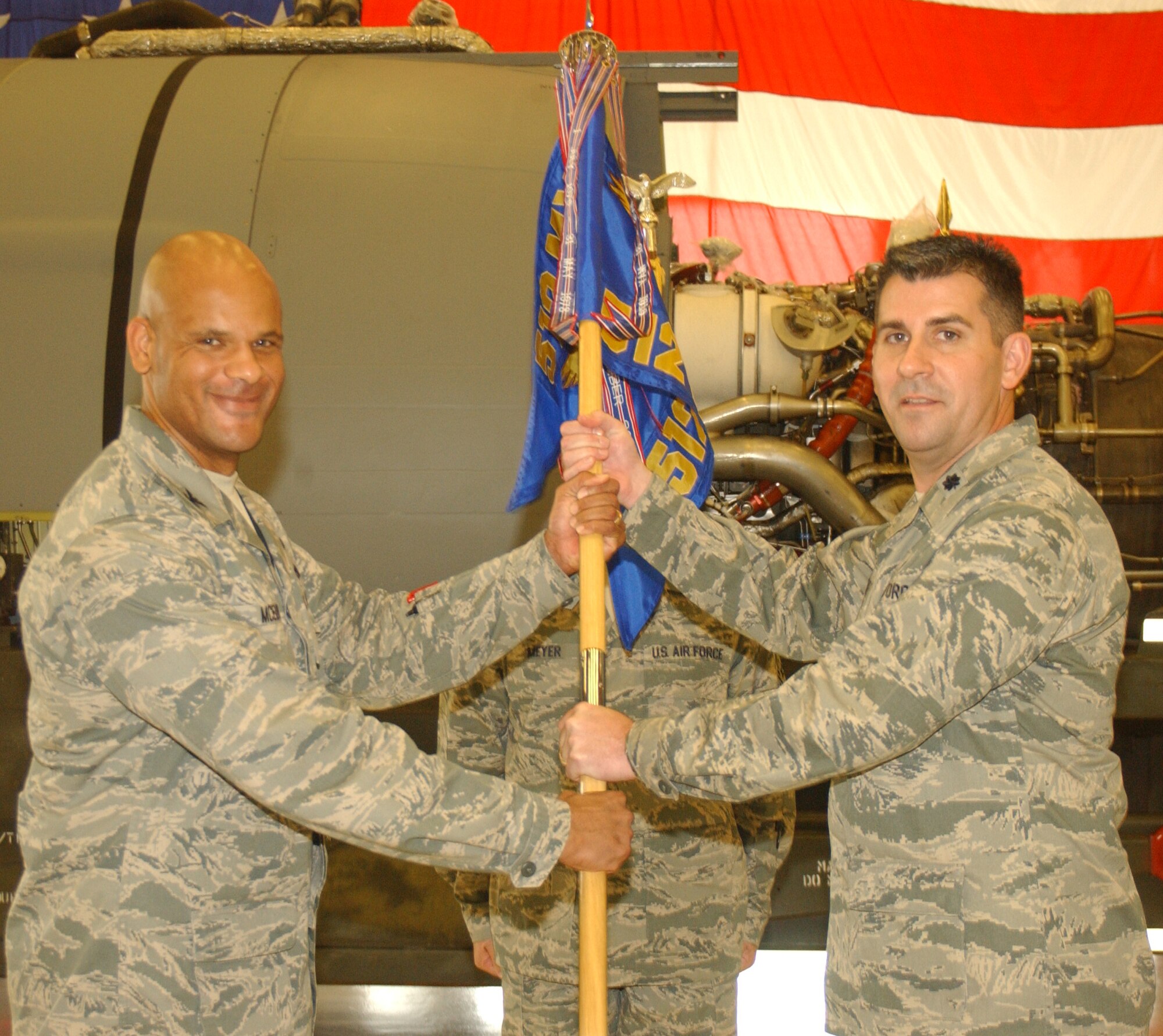 The 512th Maintenance Group Commander Col. Kelvin D. McElroy (left) presents the 512th Maintenance Squadron guide-on to Lt. Col. James Hartle, the new commander of the 512th MXS, during a ceremony May 5, 2012, in Bldg. 725, Dover Air Force Base, Del. Hartle previously served as the 512th Maintenance Operations Flight commander. (U.S. Air force photo by Staff Sgt. Timothy Ward)