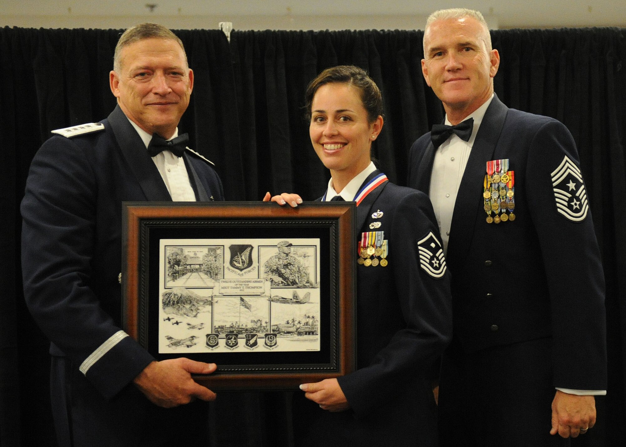 Pacific Air Forces commander Gen. Gary North and Chief Master Sgt. Brooke McLean, PACAF command chief, present Master Sgt. Tammy Thompson, First Sergeant from the 624th Civil Engineering Squadron, Joint Base Pearl Harbor-Hickam, Hawaii, with PACAF Outstanding Airman of the Year honors at the Tradewinds Enlisted Club, JBPH-H, Hawaii, April 27, 2012. (U.S. Air Force photo/Tech. Sgt. Jerome S. Tayborn)
