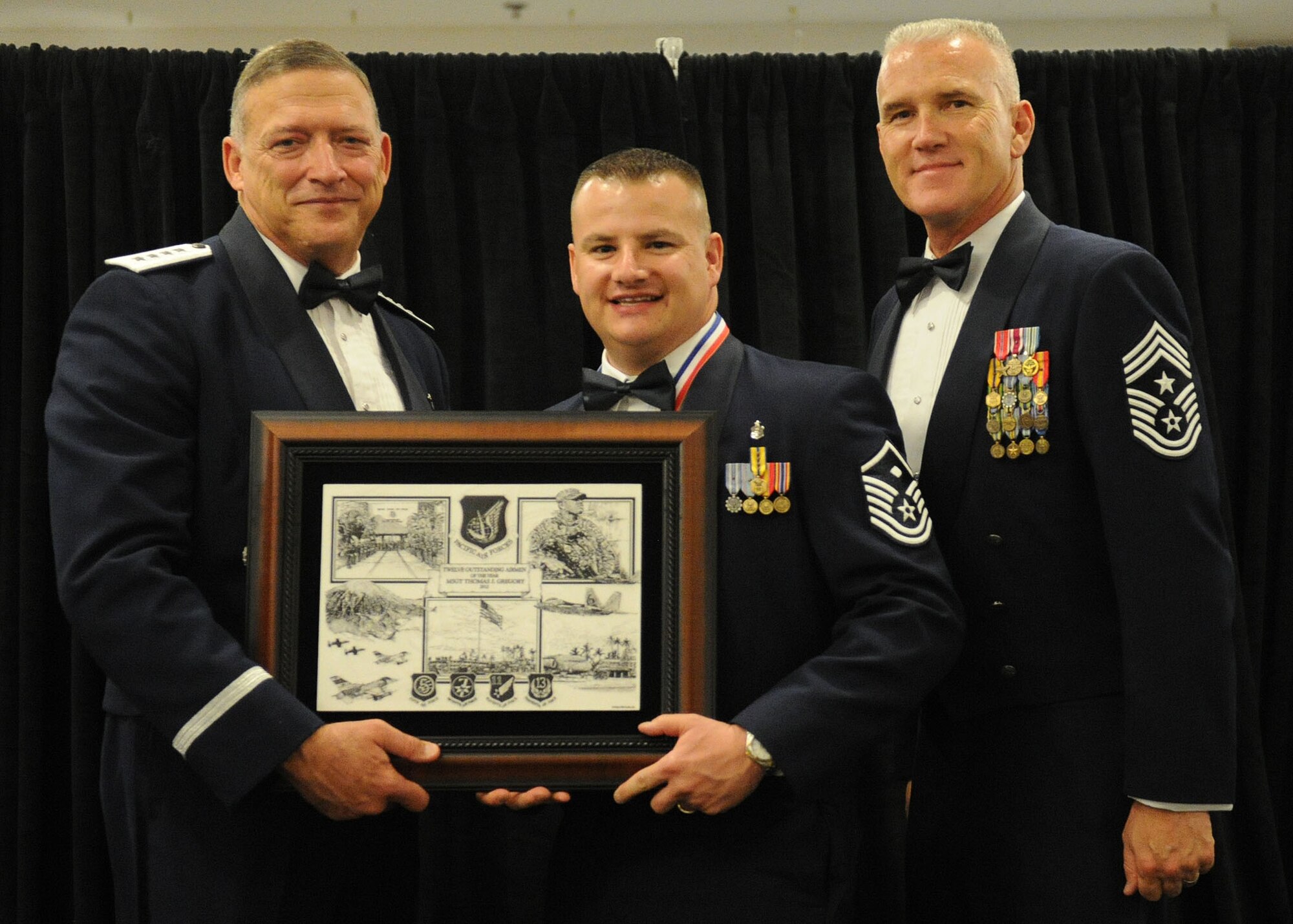 Pacific Air Forces commander Gen. Gary North and Chief Master Sgt. Brooke McLean, PACAF command chief, present Master Sgt. Thomas Gregory, First Sergeant from the 176th Security Forces Squadron, Joint Base Elmendorf-Richardson, Alaska, with PACAF Outstanding Airman of the Year honors at the Tradewinds Enlisted Club, Joint Base Pearl Harbor-Hickam, Hawaii, April 27, 2012. (U.S. Air Force photo/Tech. Sgt. Jerome S. Tayborn)