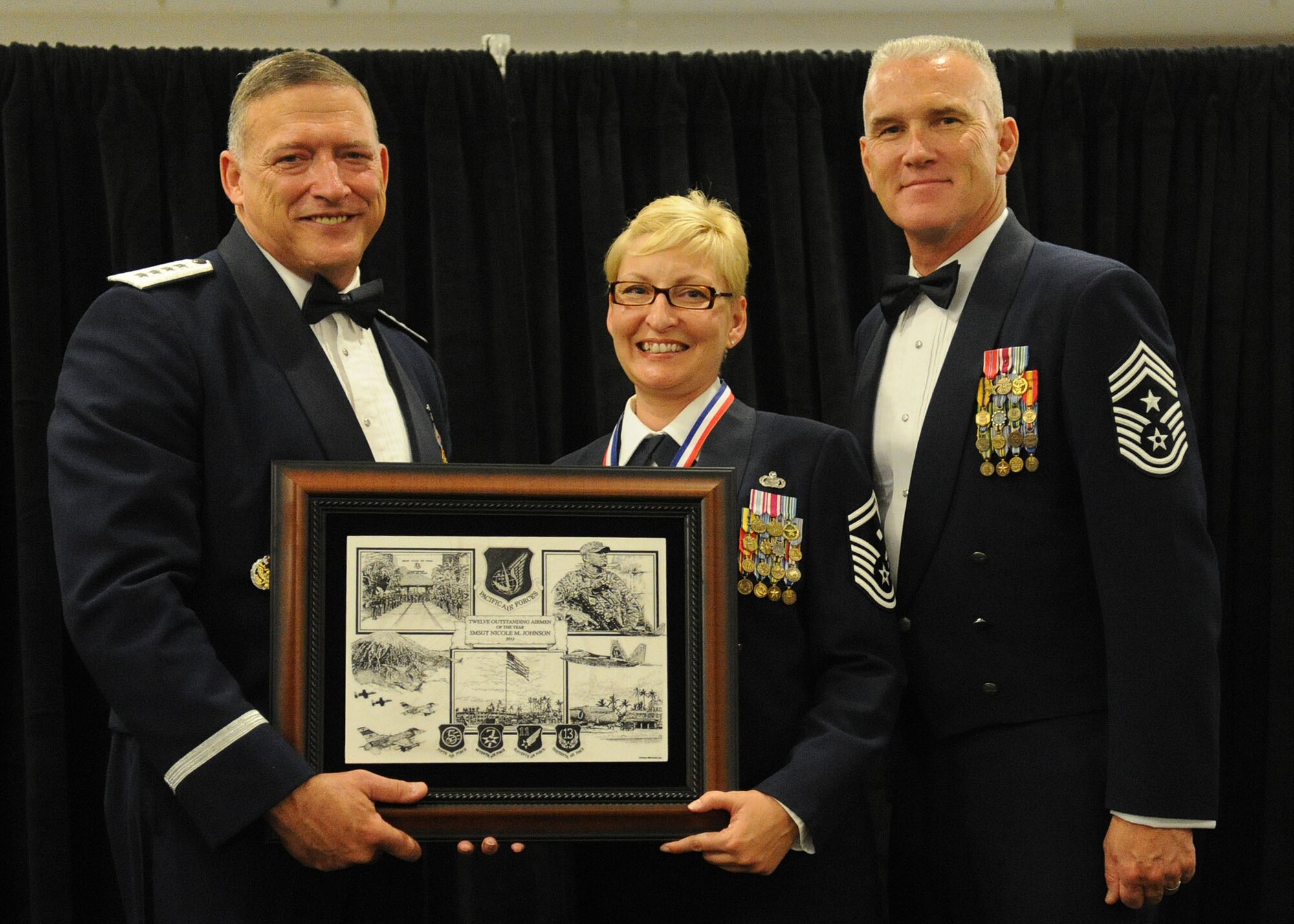 Pacific Air Forces commander Gen. Gary North and Chief Master Sgt. Brooke McLean, PACAF command chief, present Senior Master Sgt. Nicole Johnson, First Sergeant with the 613th Air and Space Operations Center, 56th Air and Space Communications Squadron and the 17th Operational Weather Squadron, Joint Base Pearl Harbor-Hickam, Hawaii, with PACAF Outstanding Airman of the Year honors at the Tradewinds Enlisted Club, JBPH-H, Hawaii, April 27, 2012. (U.S. Air Force photo/Tech. Sgt. Jerome S. Tayborn)