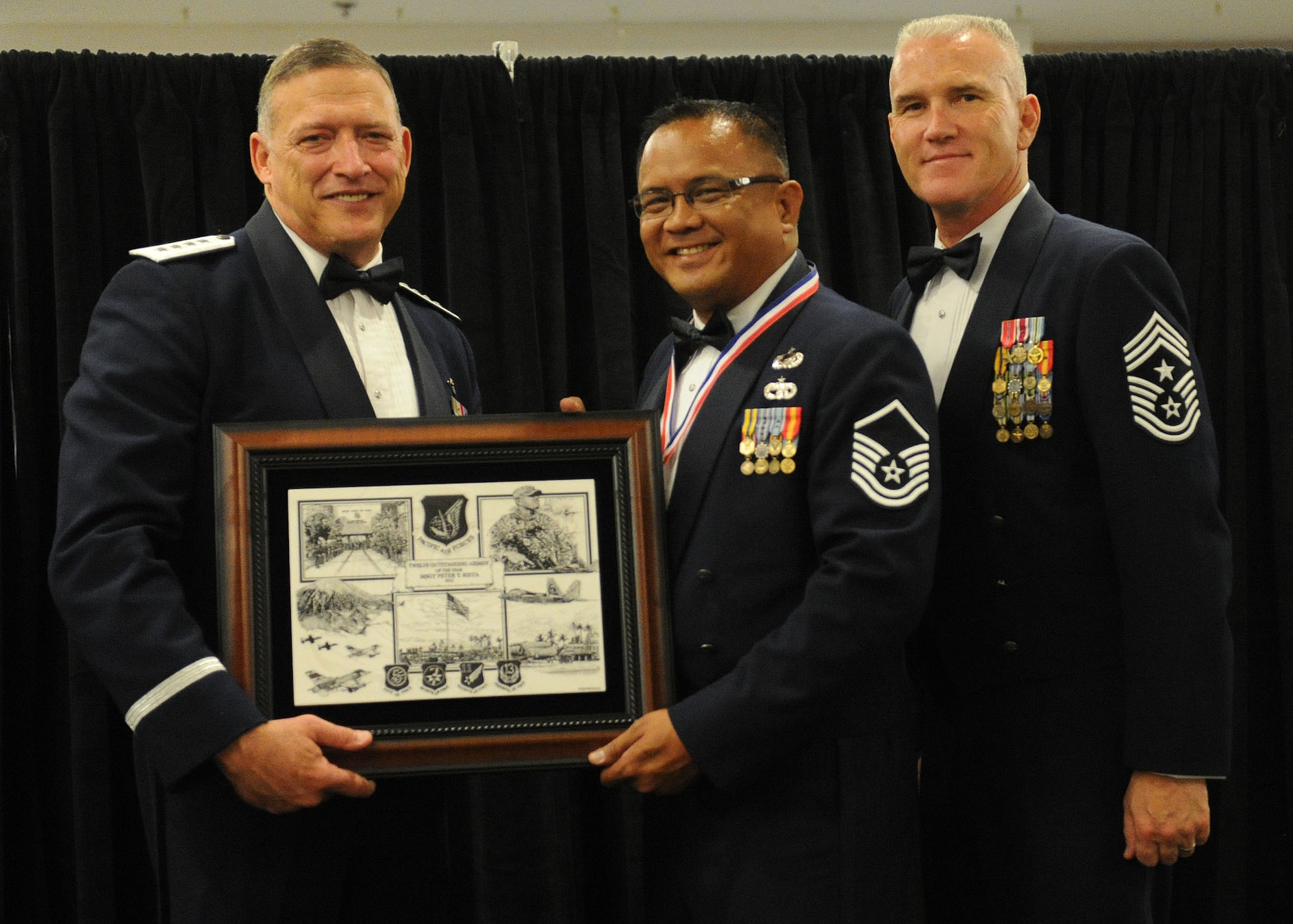 Pacific Air Forces commander Gen. Gary North and Chief Master Sgt. Brooke McLean, PACAF command chief, present Master Sgt. Peter Rieta, unit training manager from the 48th Aerial Port Squadron, Joint Base Pearl Harbor-Hickam, Hawaii, with PACAF Outstanding Airman of the Year honors at the Tradewinds Enlisted Club, JBPH-H, Hawaii, April 27, 2012. (U.S. Air Force photo/Tech. Sgt. Jerome S. Tayborn)